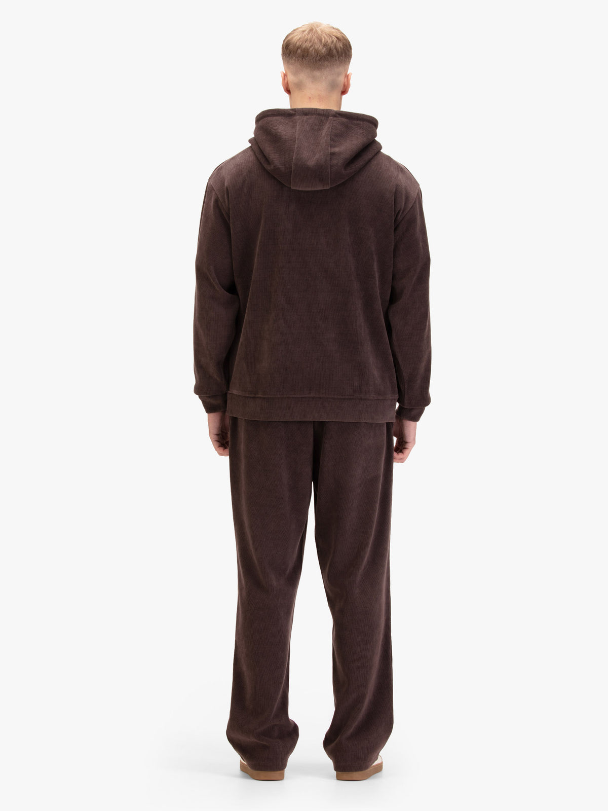 Men's relaxed-fit brown tracksuit with pullover hoodie and matching joggers, worn by a model, back view.