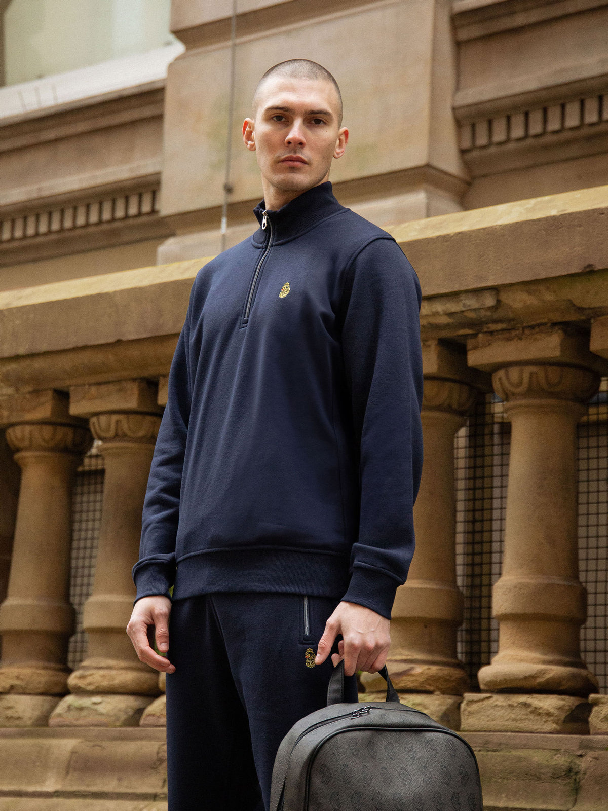 Men's navy tracksuit with quarter zip sweatshirt and matching joggers.