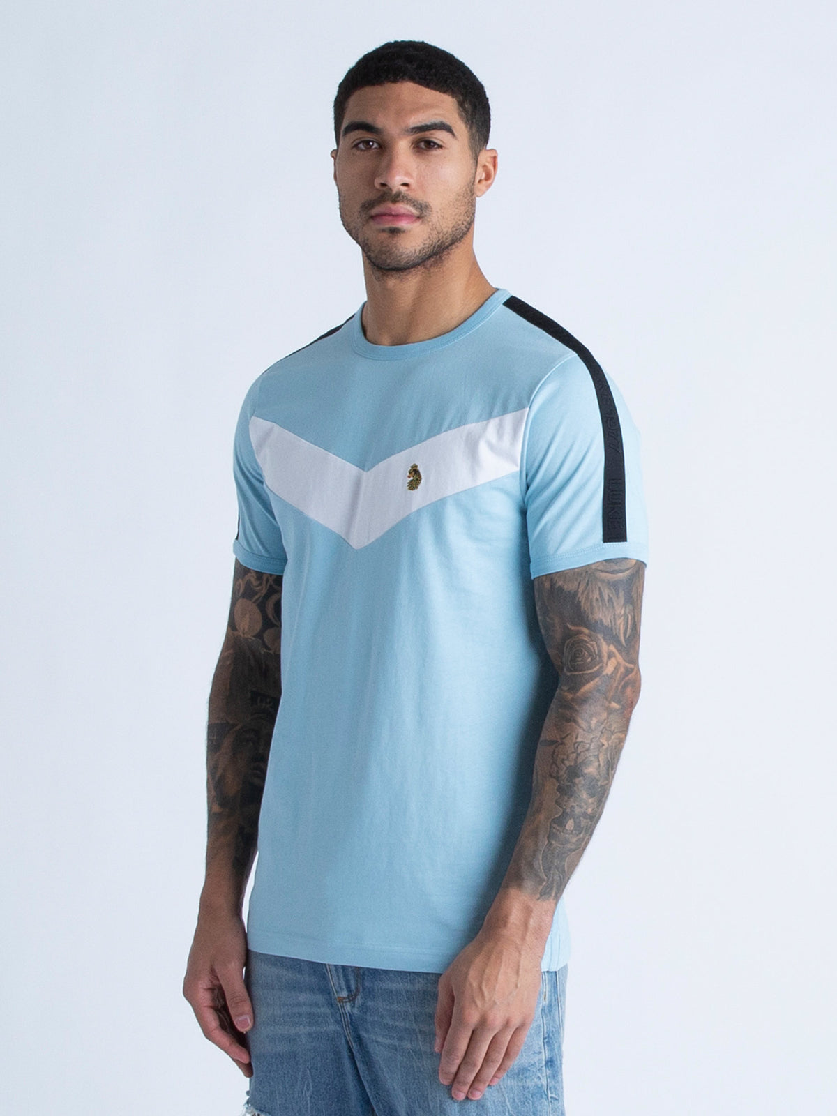 Men's blue t-shirt with crew neck and short sleeves worn by a model - side view.