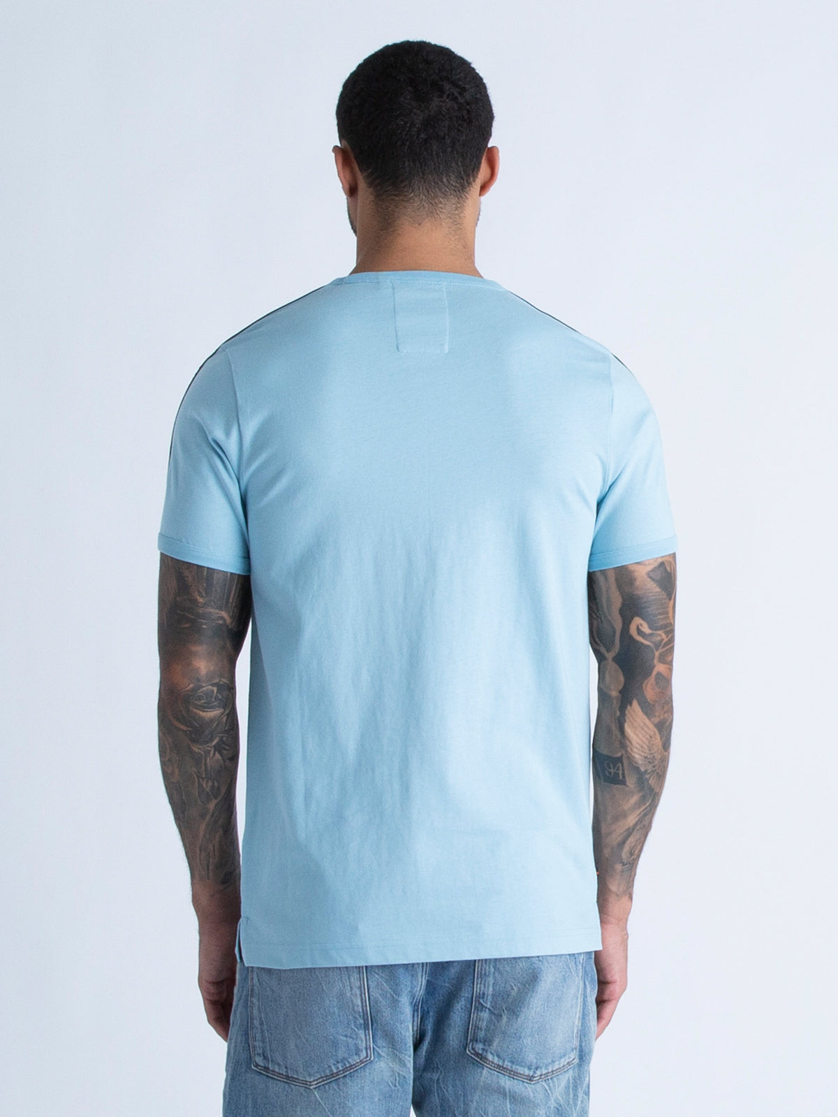 Men's blue t-shirt with crew neck and short sleeves worn by a model - back view.