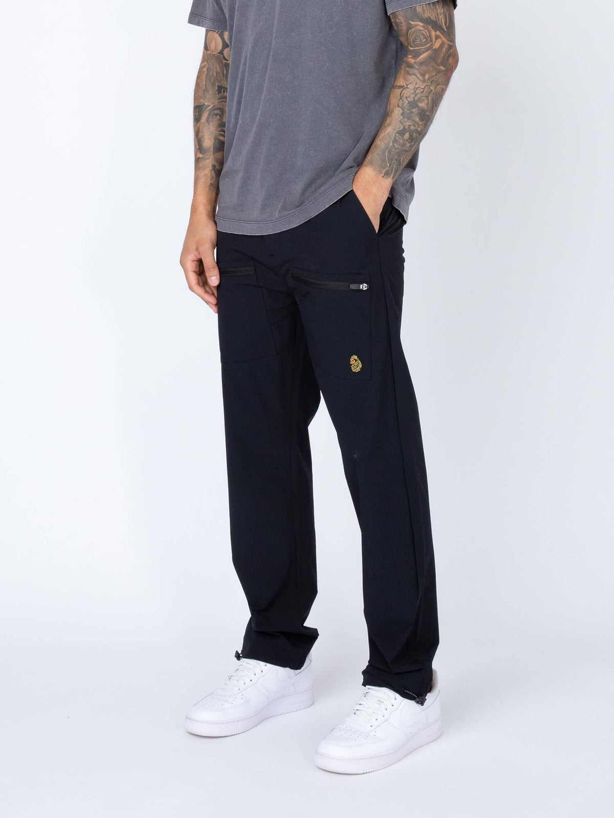 Men's black cargo trousers with cargo pockets, worn by a model, side view