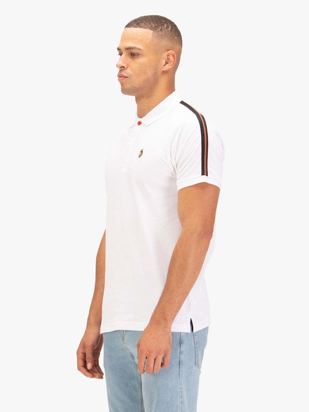 Side view of man wearing white LUKE 1977 New Willtape polo shirt showing LUKE 1977 tape