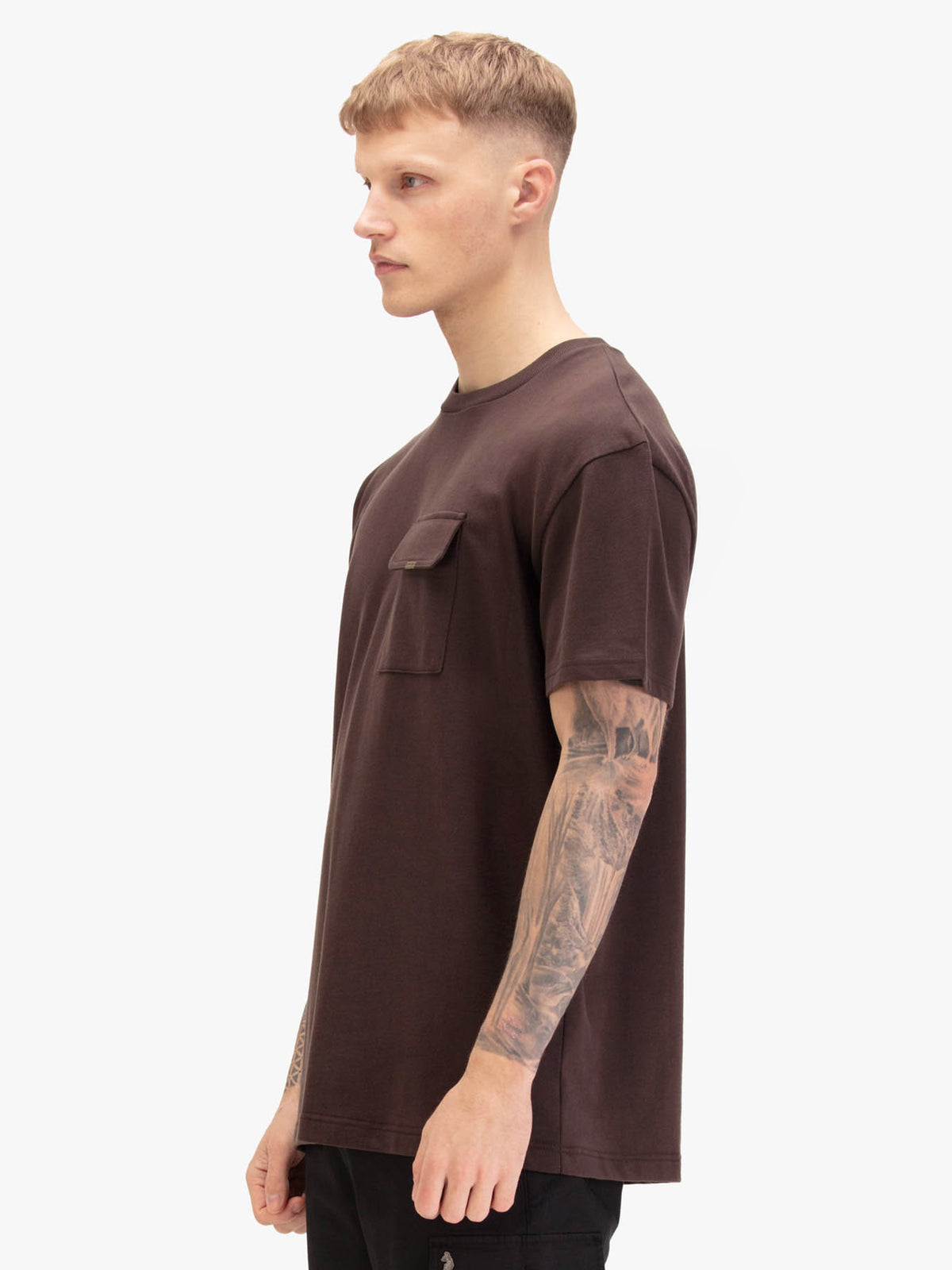 Men's relaxed-fit brown t-shirt with crew neck and short sleeves, worn by a model, side view