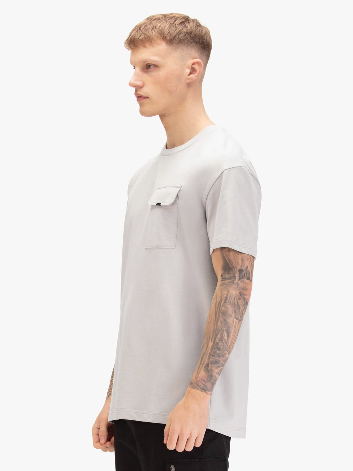 Men's relaxed-fit grey t-shirt with crew neck and short sleeves, worn by a model, side view