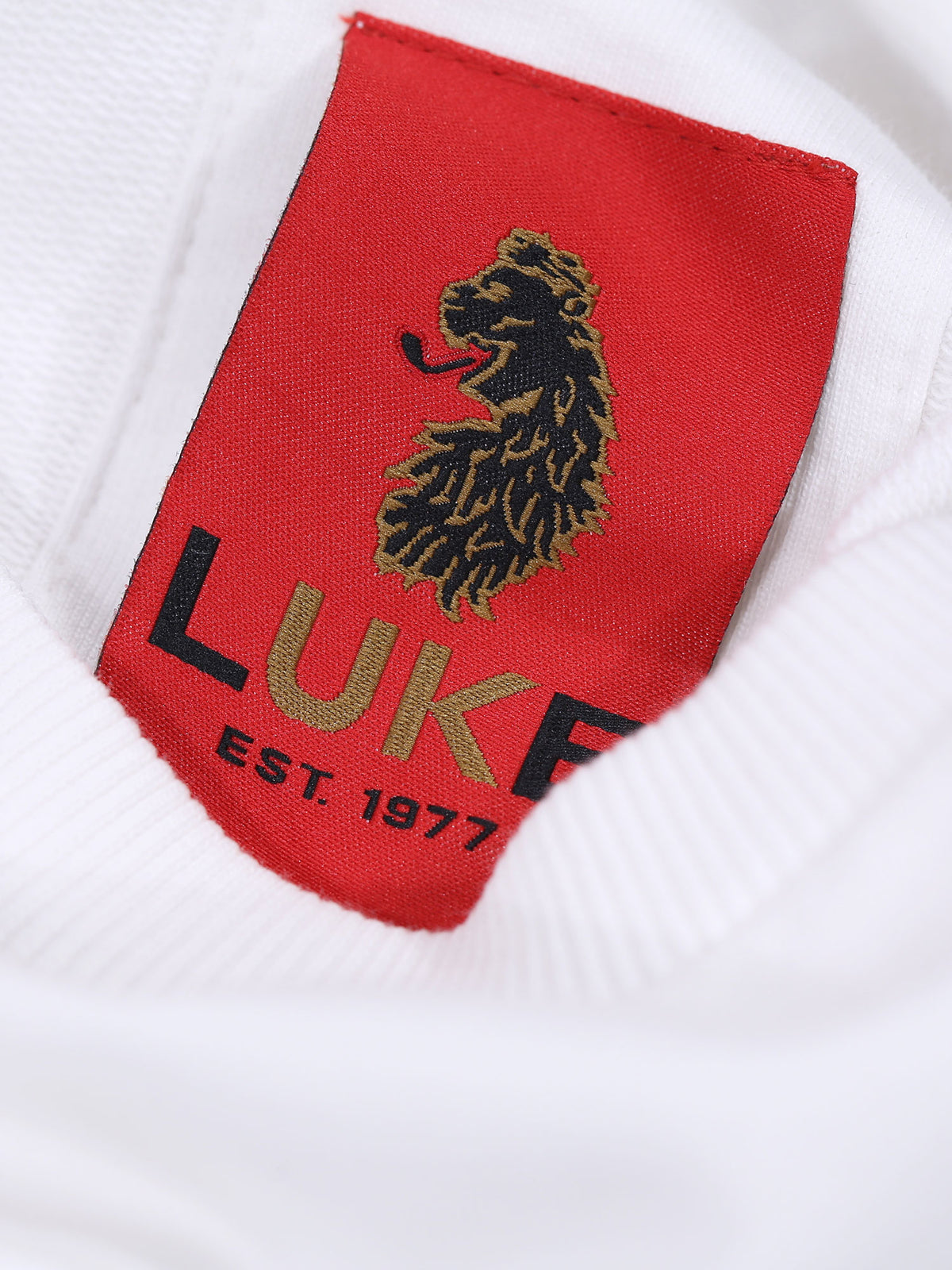 Close-up of red LUKE EST. 1977 neck label inside white Dragger t-shirt