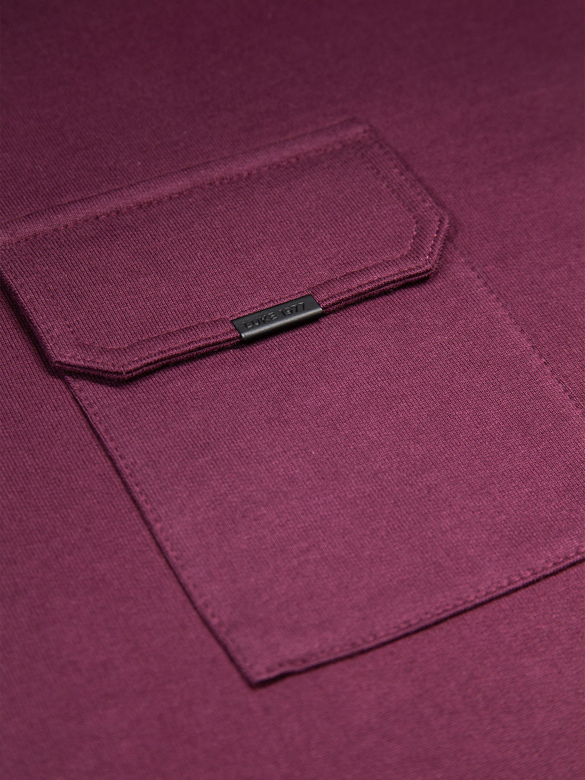 Close-up of chest pocket with LUKE 1977 metal clip on wine red Dragger t-shirt