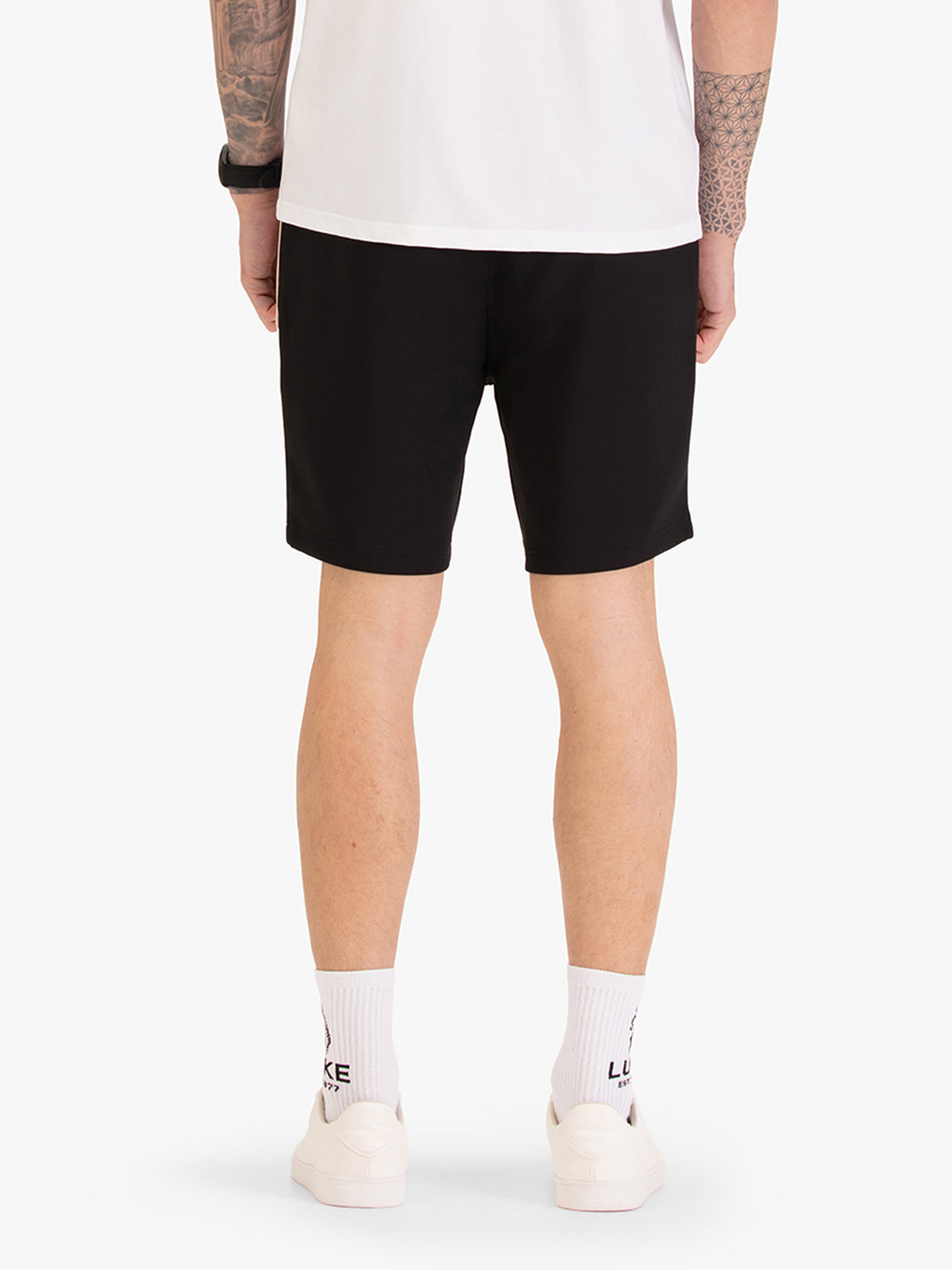 Men's black shorts with drawstring waistband, worn by a model, back view