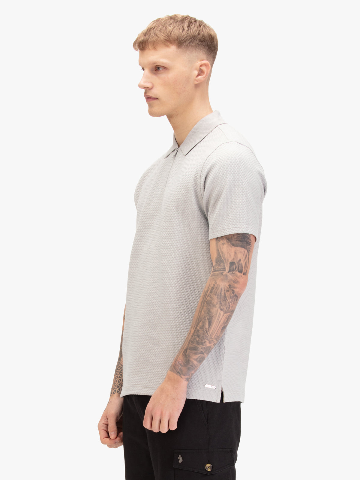 Men's grey polo shirt with polo collar, worn by a model, side view