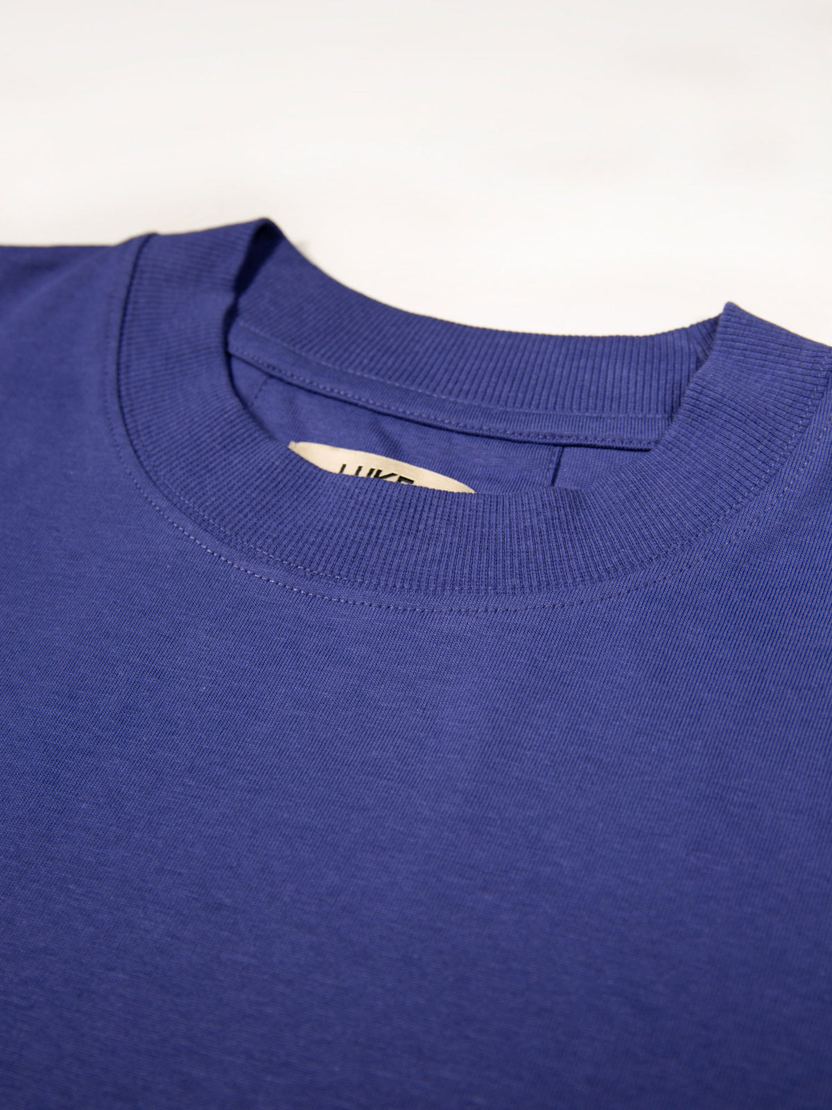 Men's purple t-shirt with crew neck and short sleeves worn by a model - back view.