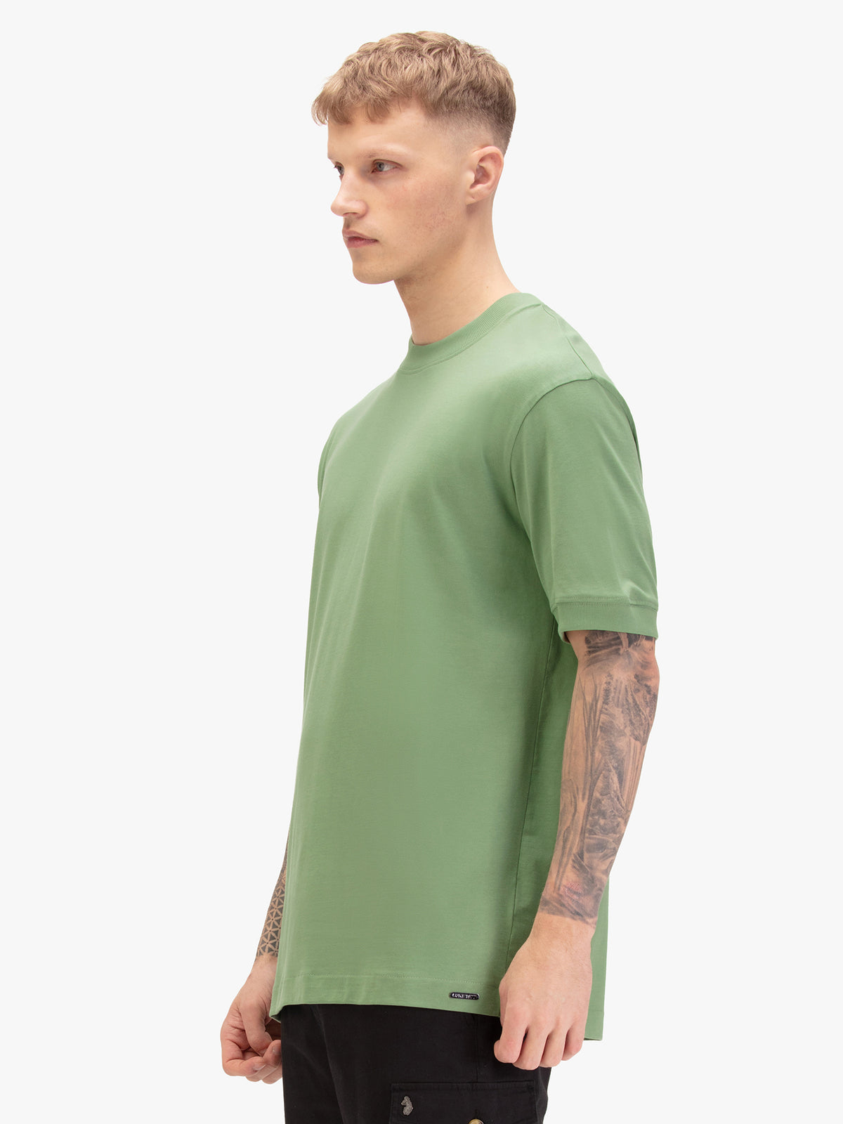 Men's relaxed-fit green t-shirt with crew neck and short sleeves, worn by a model, side view