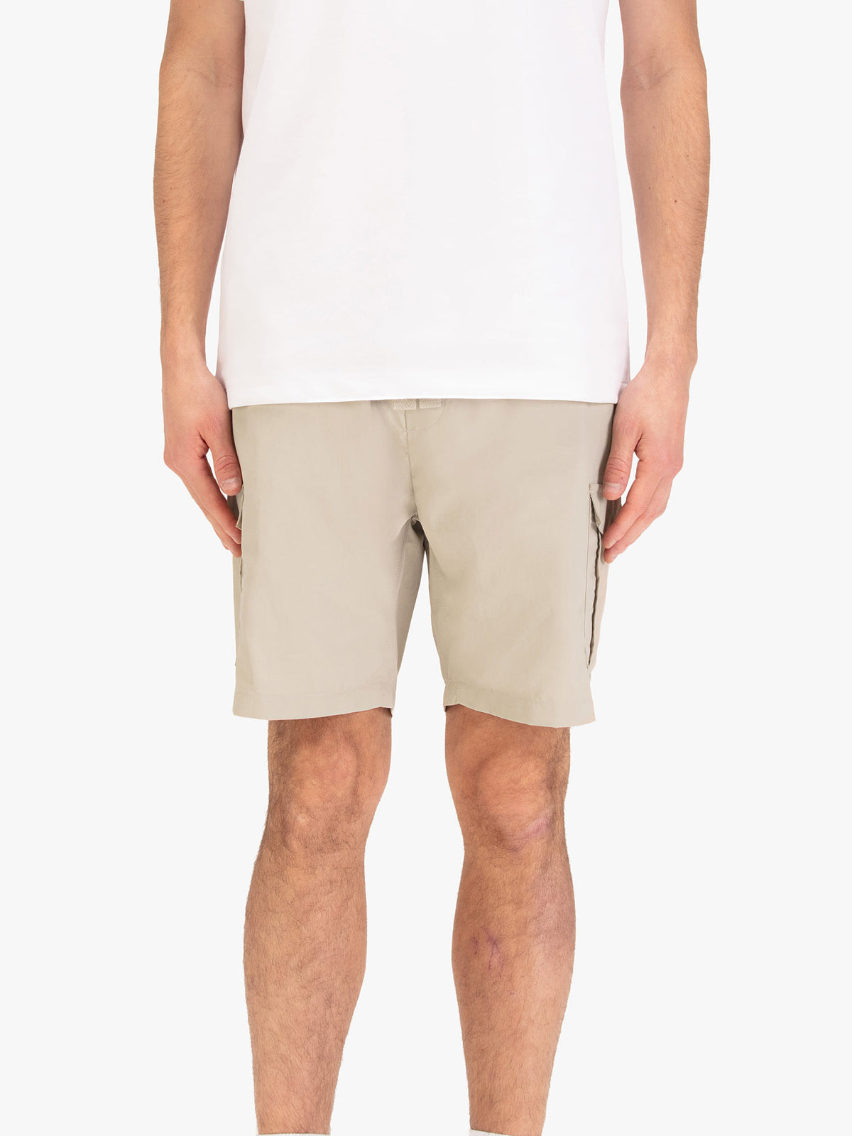 Men's beige shorts with elasticated waistband, worn by a model, front view
