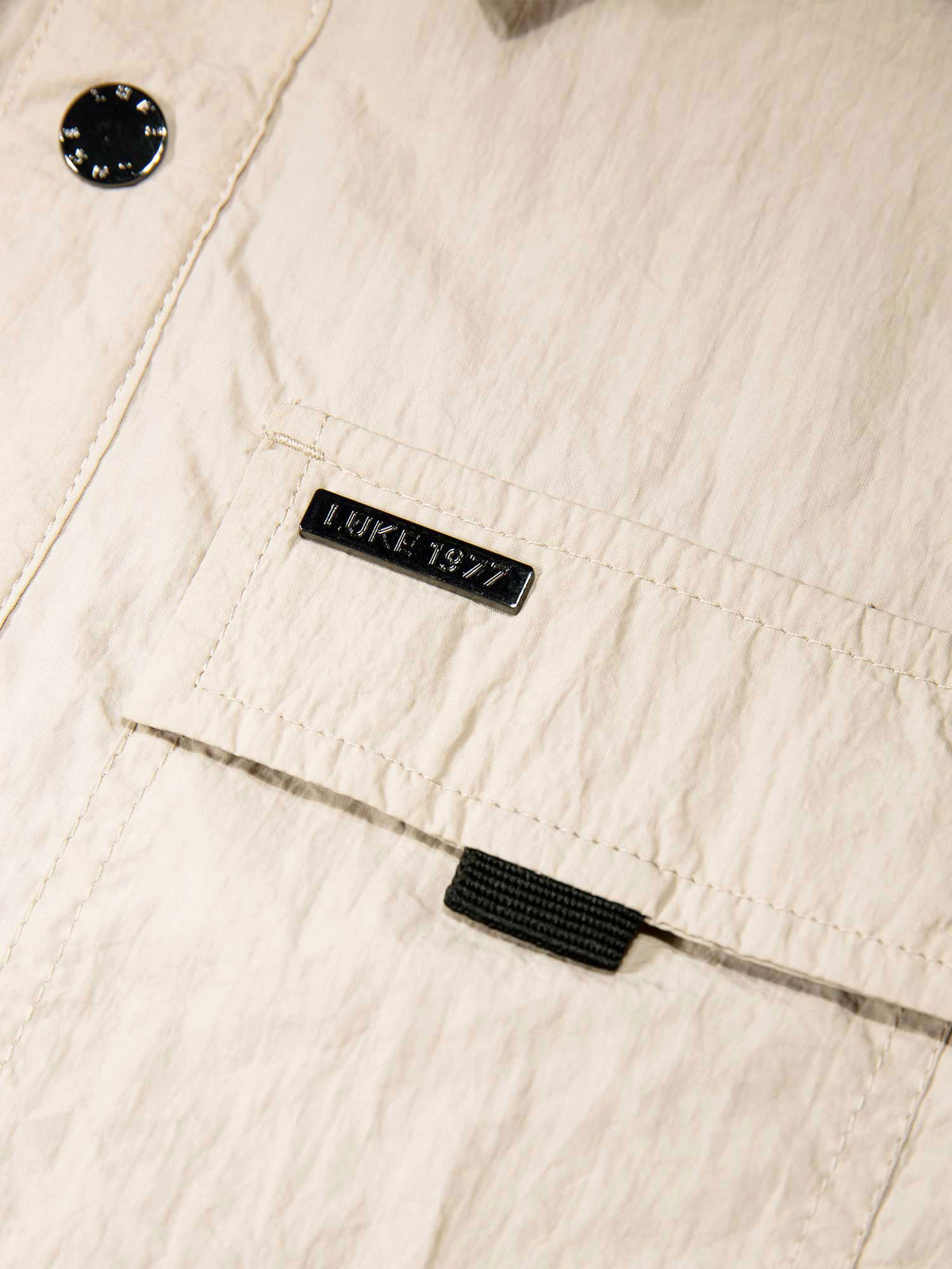 Men's beige jacket with button-up front and chest pocket.