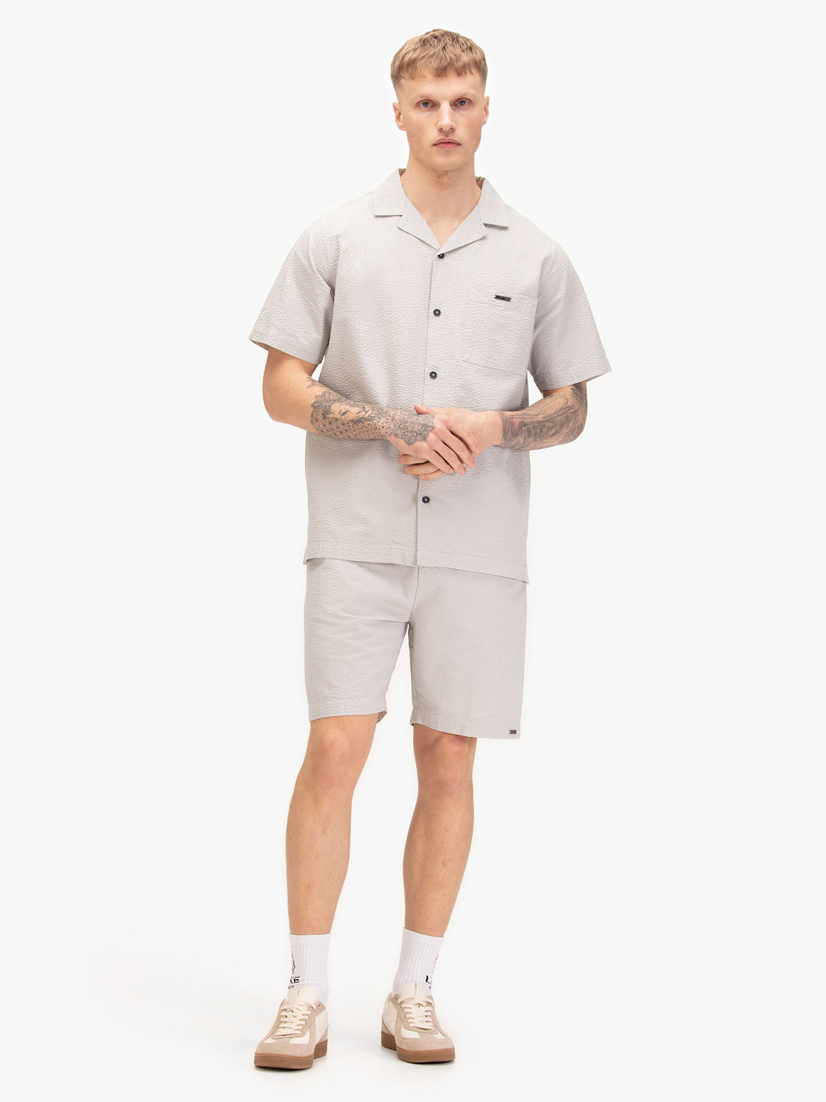 Men's grey short set with short-sleeve button-up shirt and matching shorts, worn by a model.