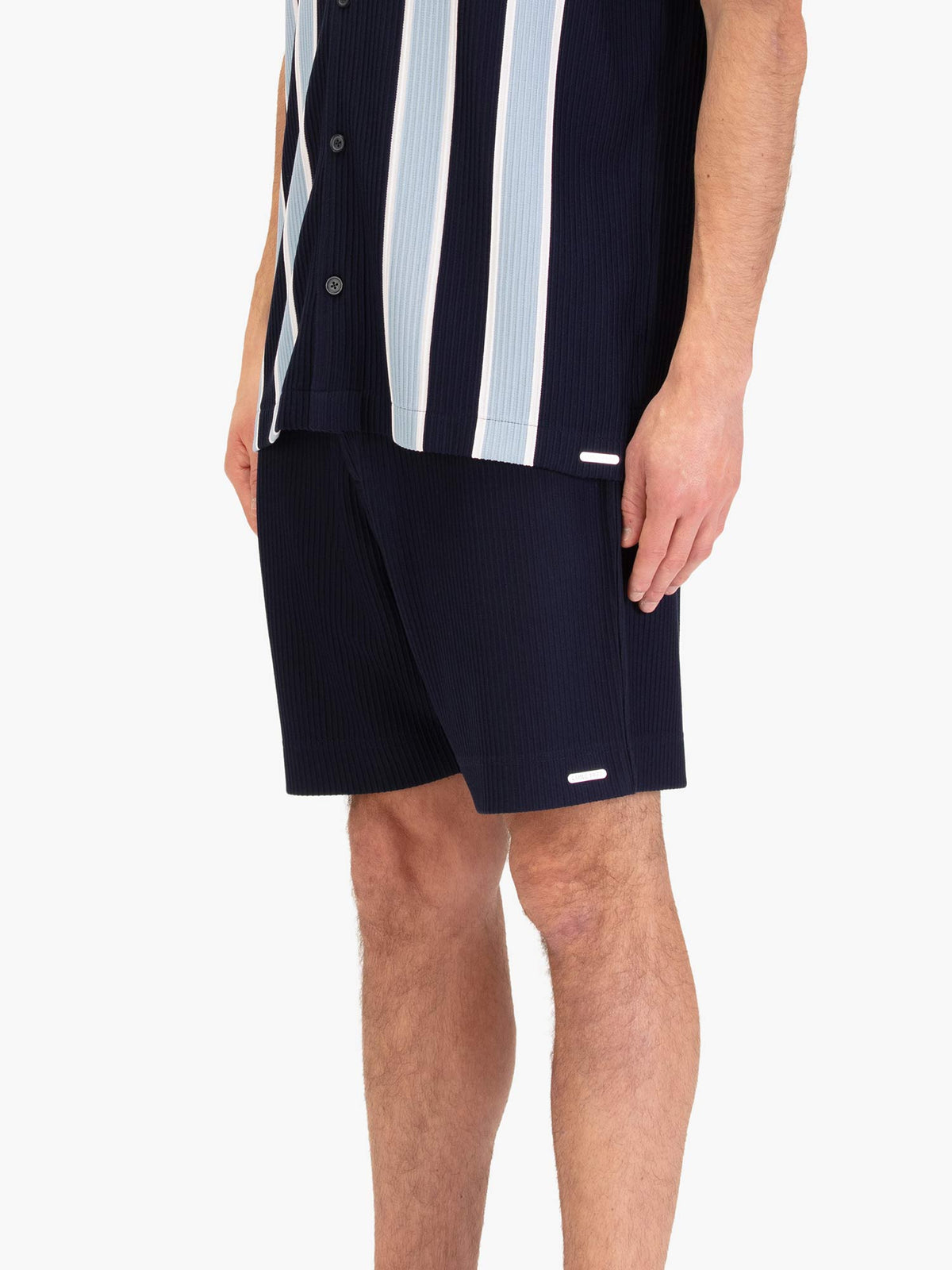 Men's navy shorts with drawstring waistband, worn by a model, side view