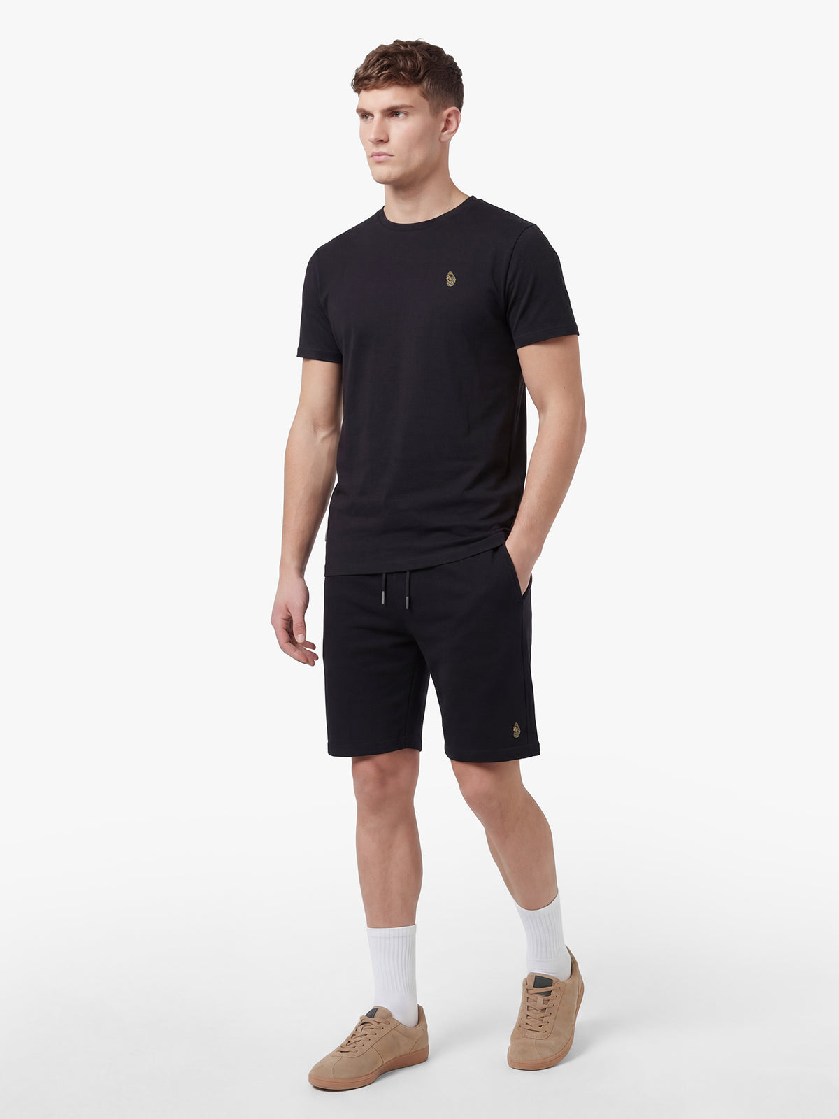 Men's black short set with short-sleeve shirt and drawstring shorts, worn by a model, side view.