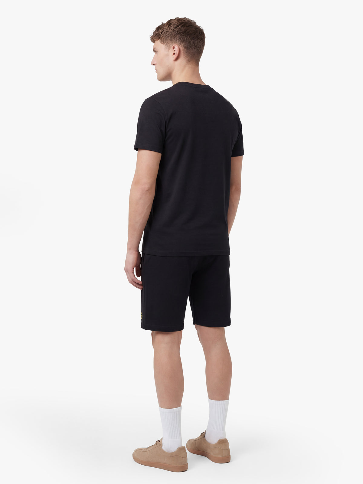 Men's black short set with short-sleeve shirt and drawstring shorts, worn by a model, back view.