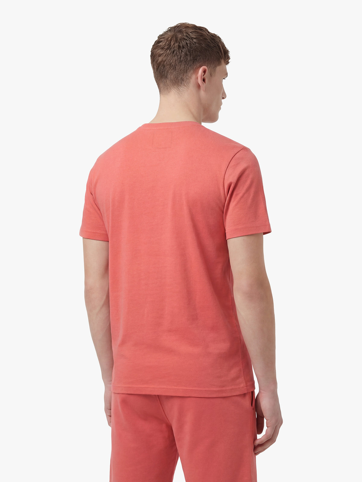 Men's red short set with short-sleeve shirt and drawstring shorts, worn by a model, back view.