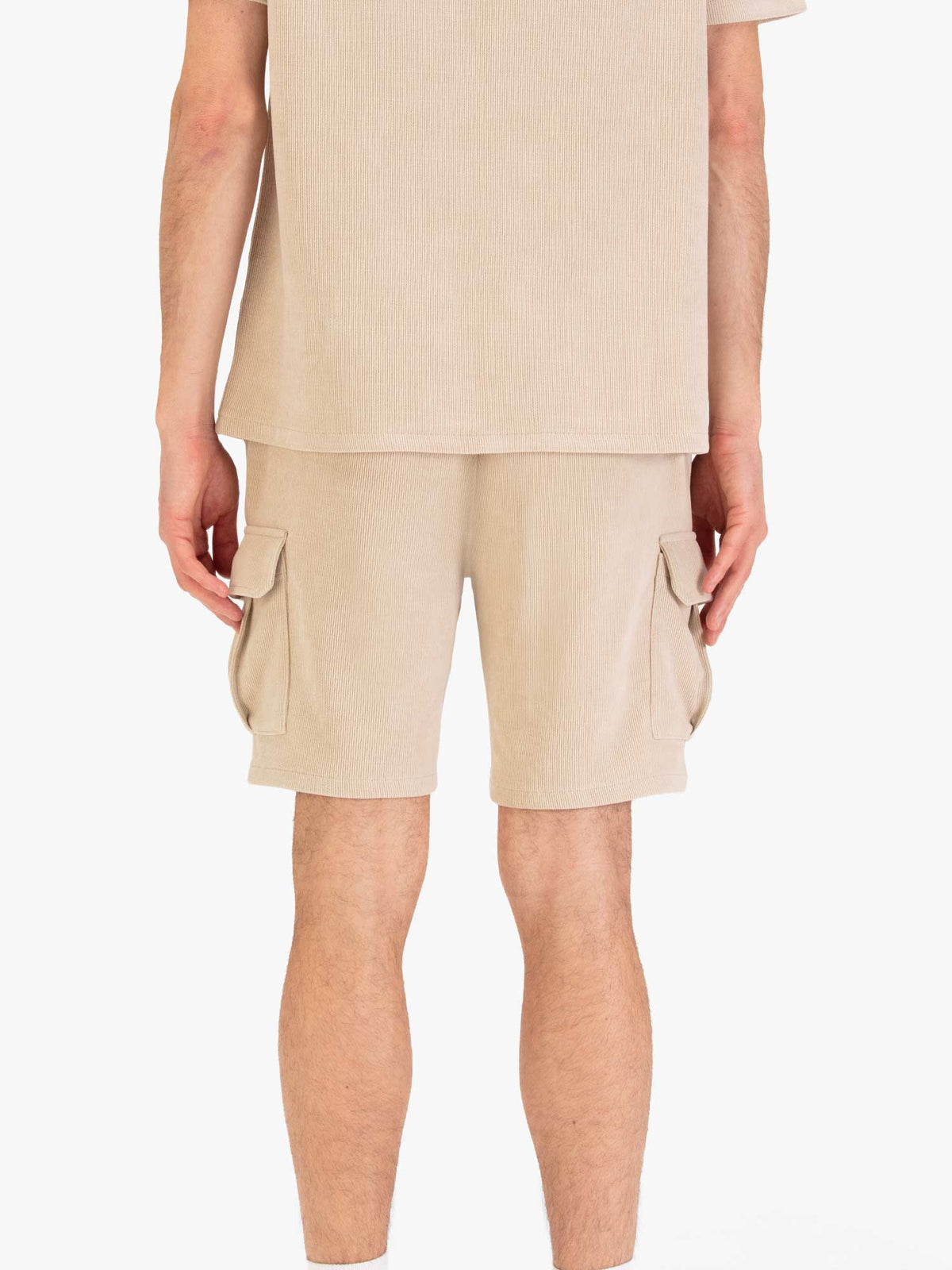 Men's beige shorts with drawstring waistband and cargo pockets, worn by a model, back view