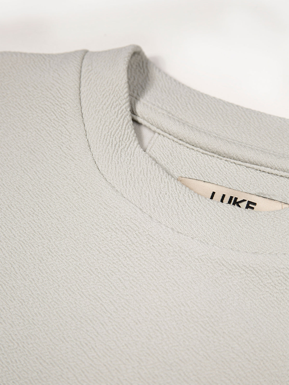 Men's grey t-shirt with crew neck and short sleeves worn by a model - side view.