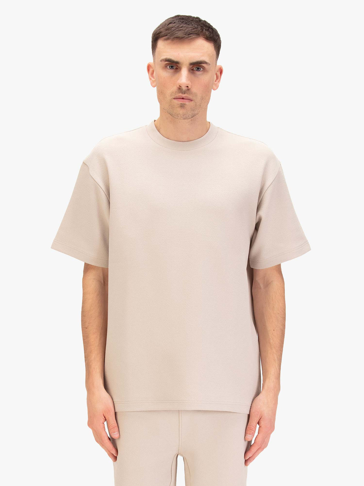 Men's relaxed-fit beige t-shirt with crew neck and short sleeves, worn by a model, front view