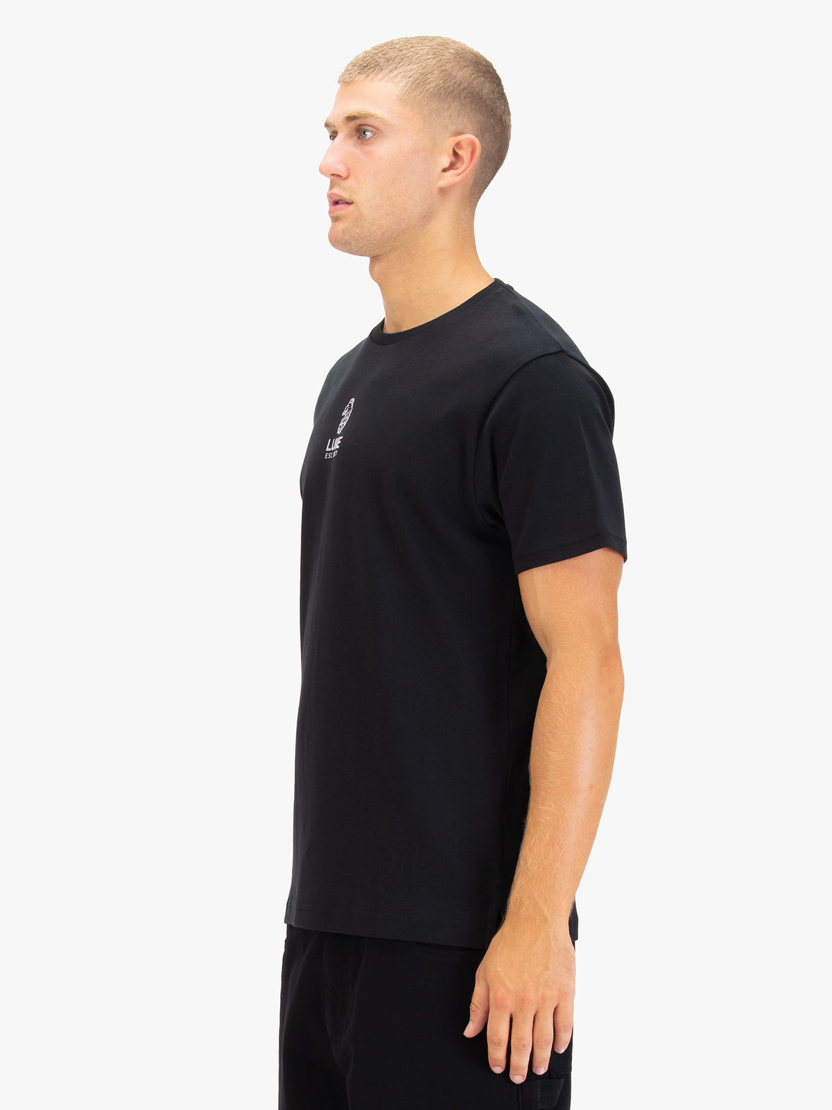 Men's black t-shirt with crew neck and short sleeves worn by a model - side view.