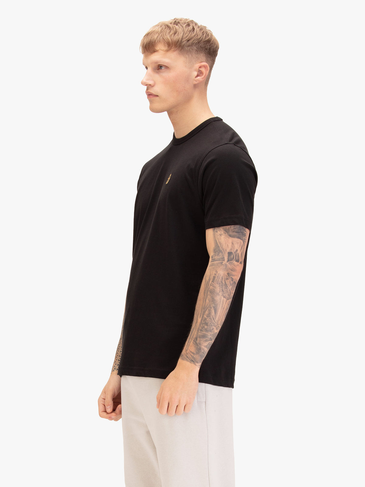 Men's black t-shirt with crew neck and short sleeves, worn by a model, side view