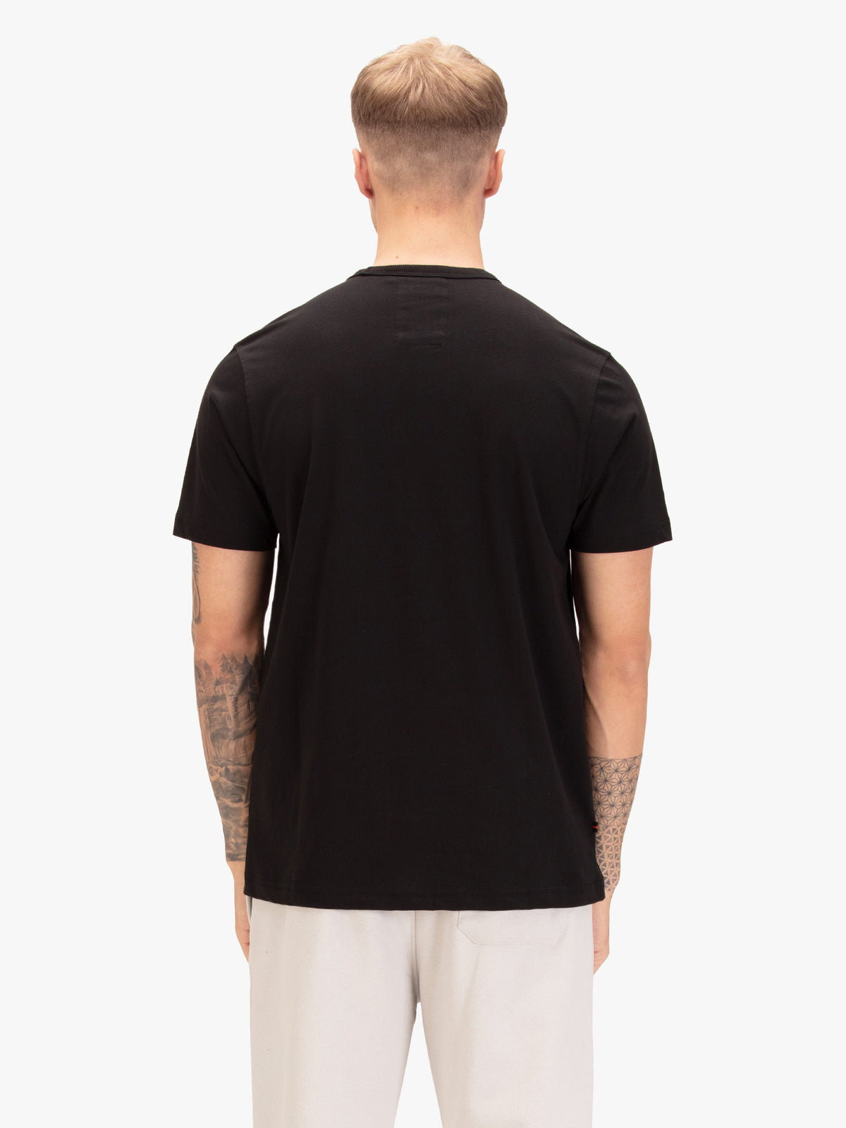 Men's black t-shirt with crew neck and short sleeves, worn by a model, back view
