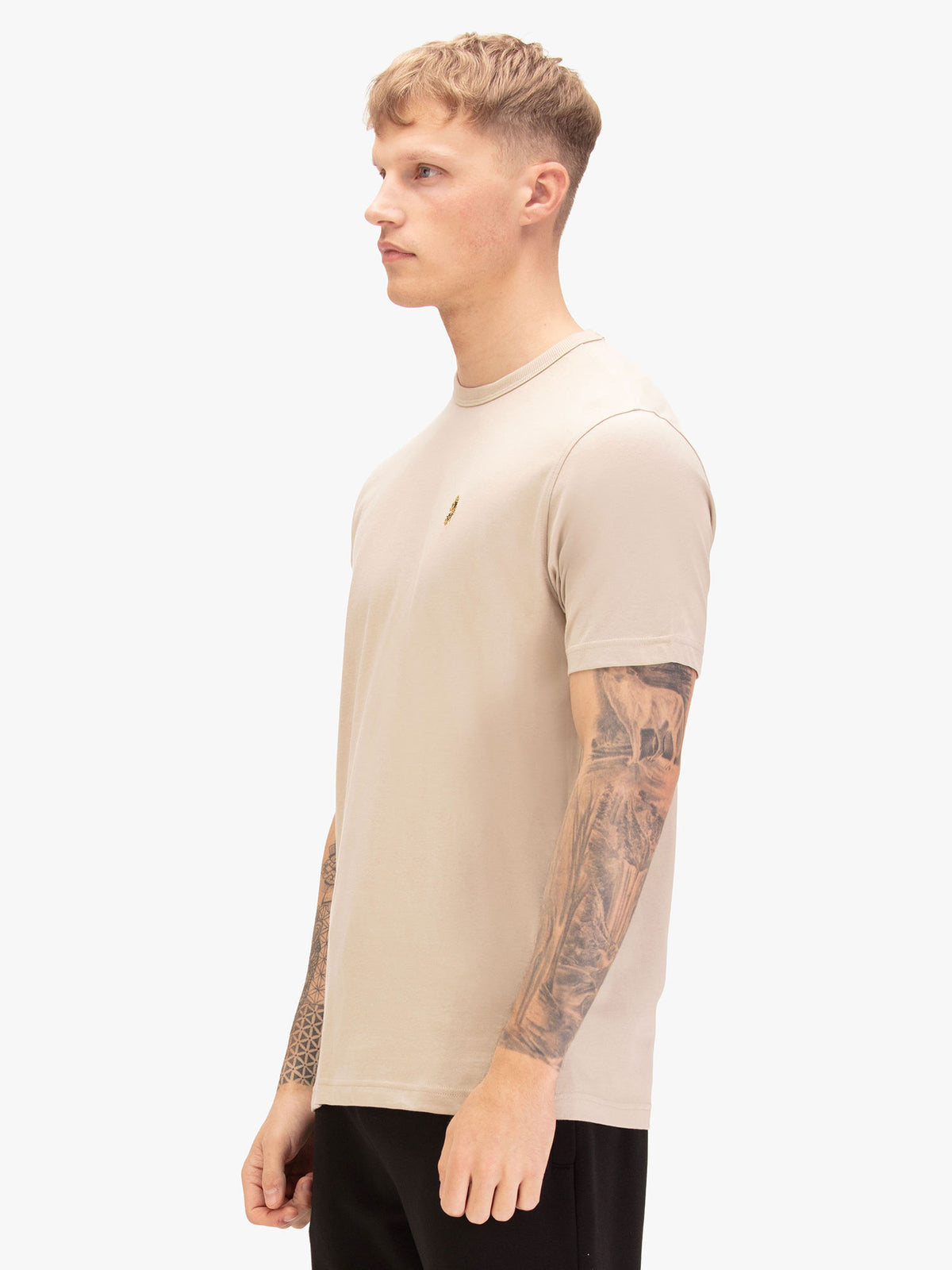 Men's beige t-shirt with crew neck and short sleeves, worn by a model, side view