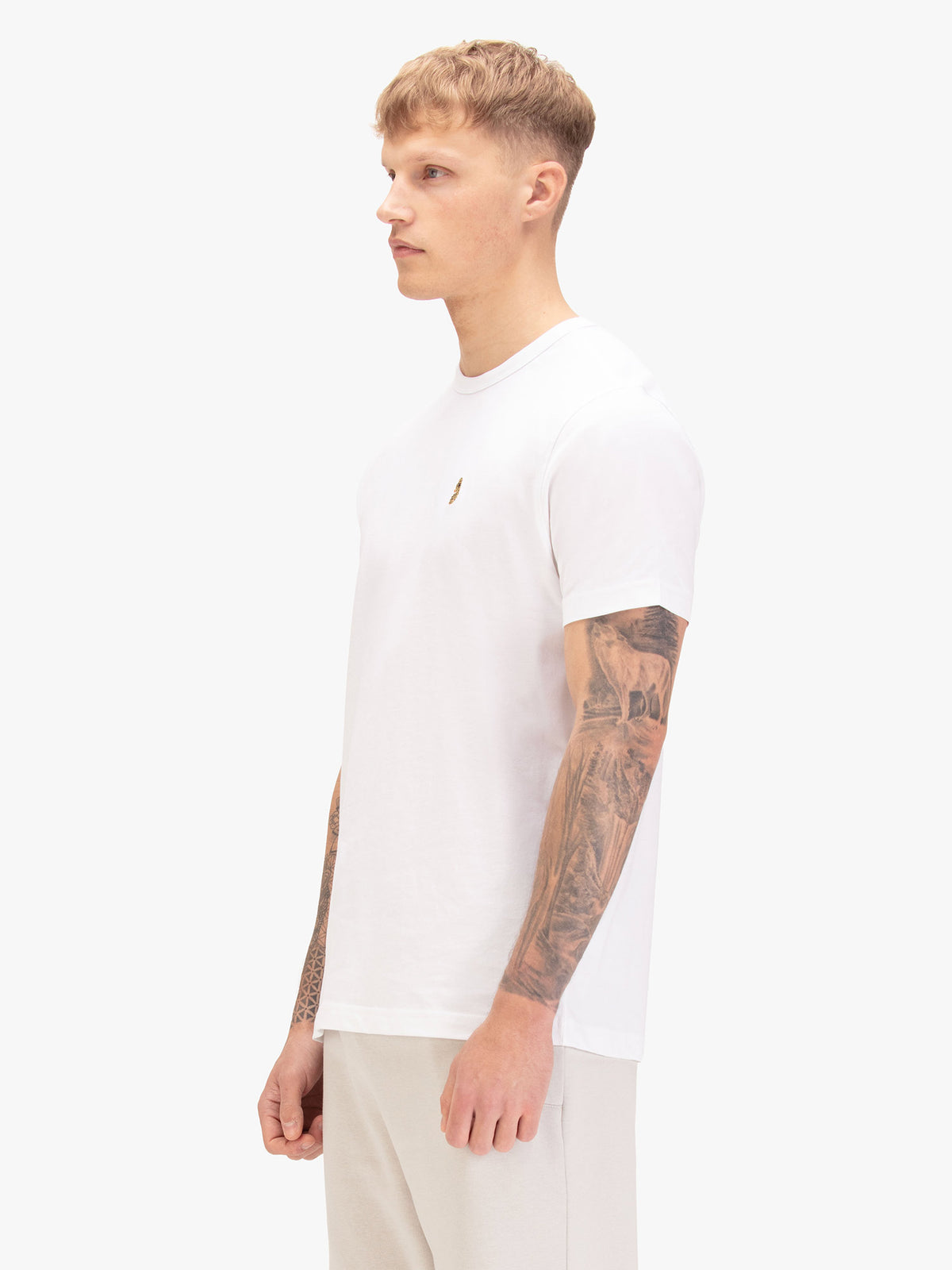 Men's white t-shirt with crew neck and short sleeves, worn by a model, side view