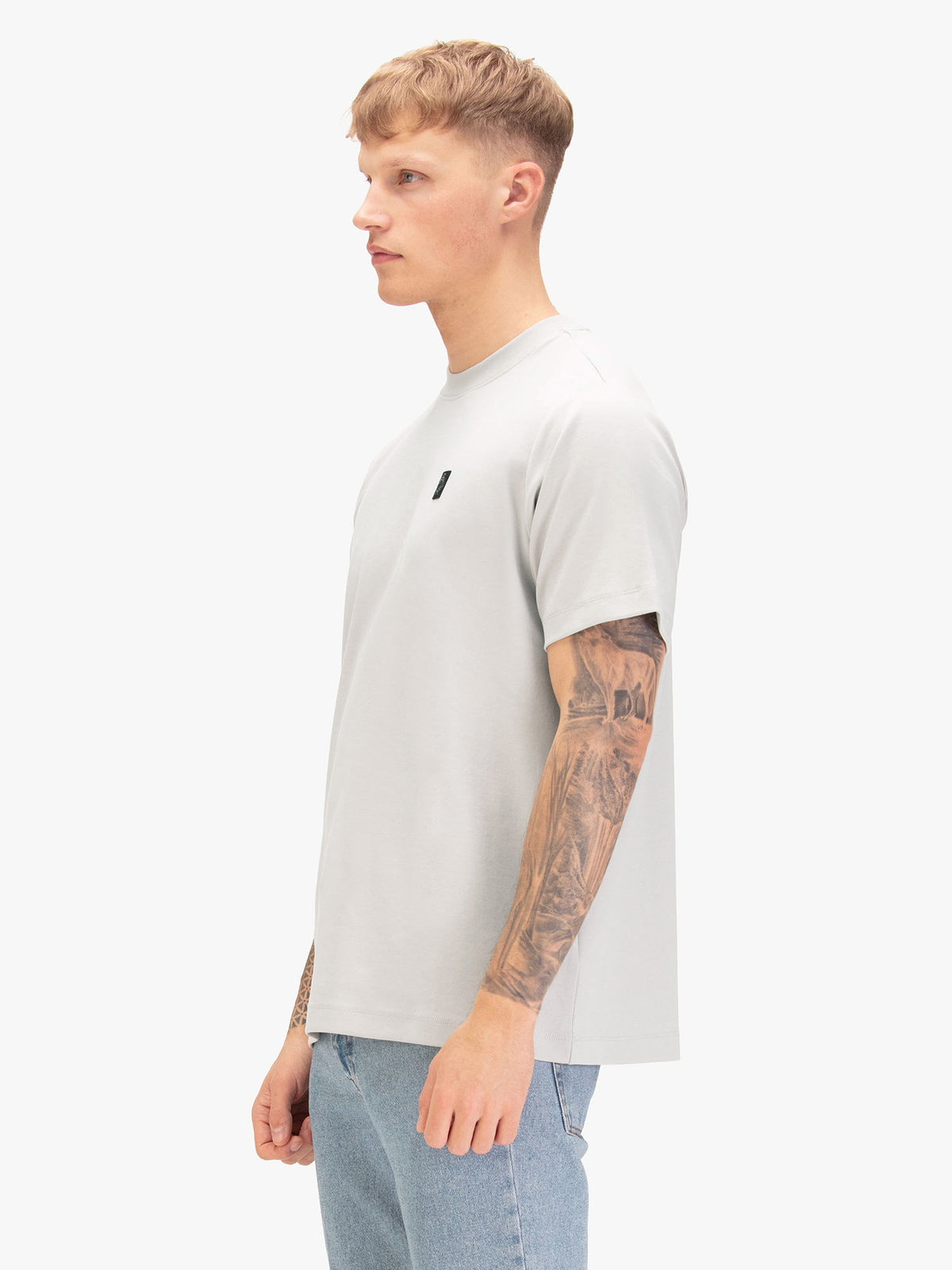Men's relaxed-fit grey t-shirt with crew neck and short sleeves, worn by a model, side view