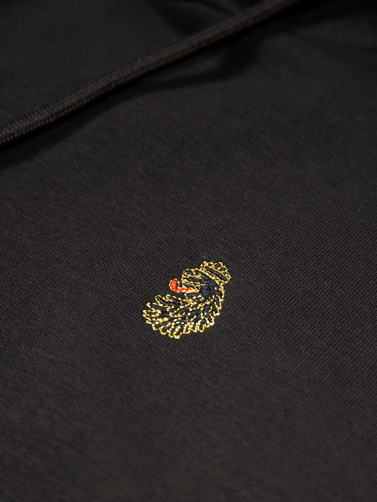 Men's black tracksuit with hoodie and matching joggers, detail view.