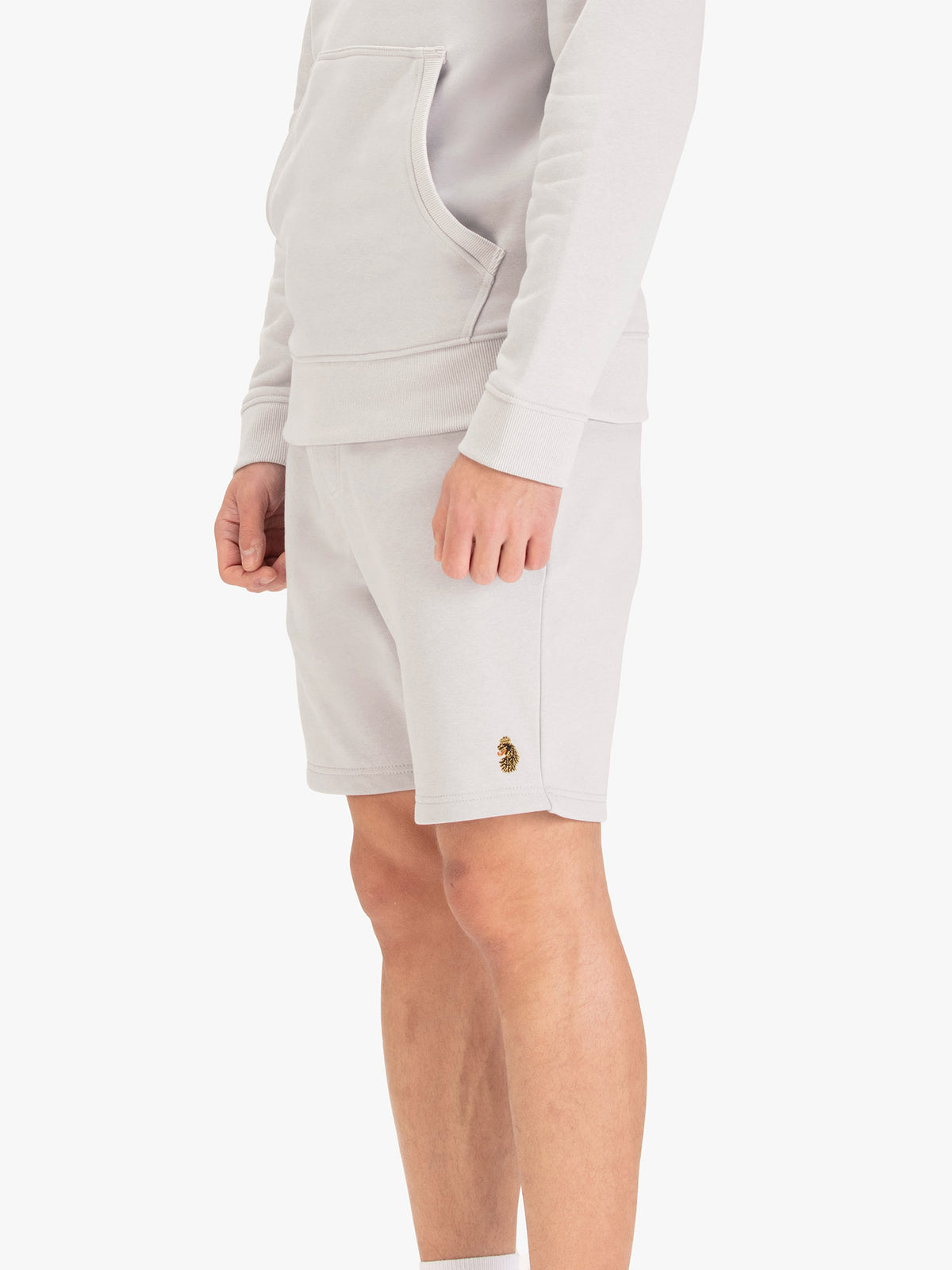 Men's grey shorts with drawstring waistband, worn by a model, worn by a model, side view