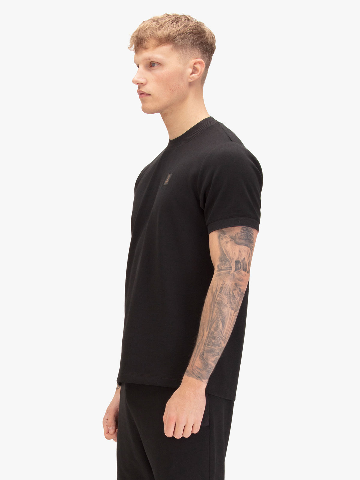 Men's black t-shirt with crew neck and short sleeves, worn by a model, side view