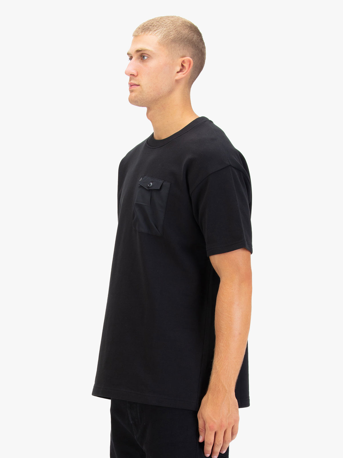 Men's black t-shirt with crew neck and short sleeves worn by a model - side view.
