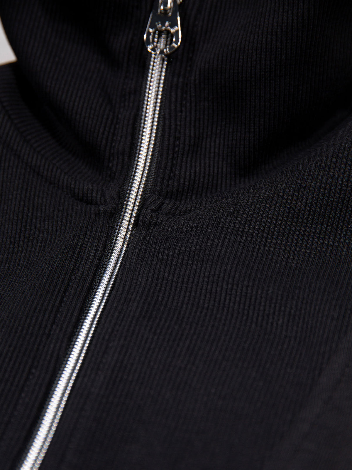 Close-up of chrome quarter zip on black Jan Jose sweatshirt