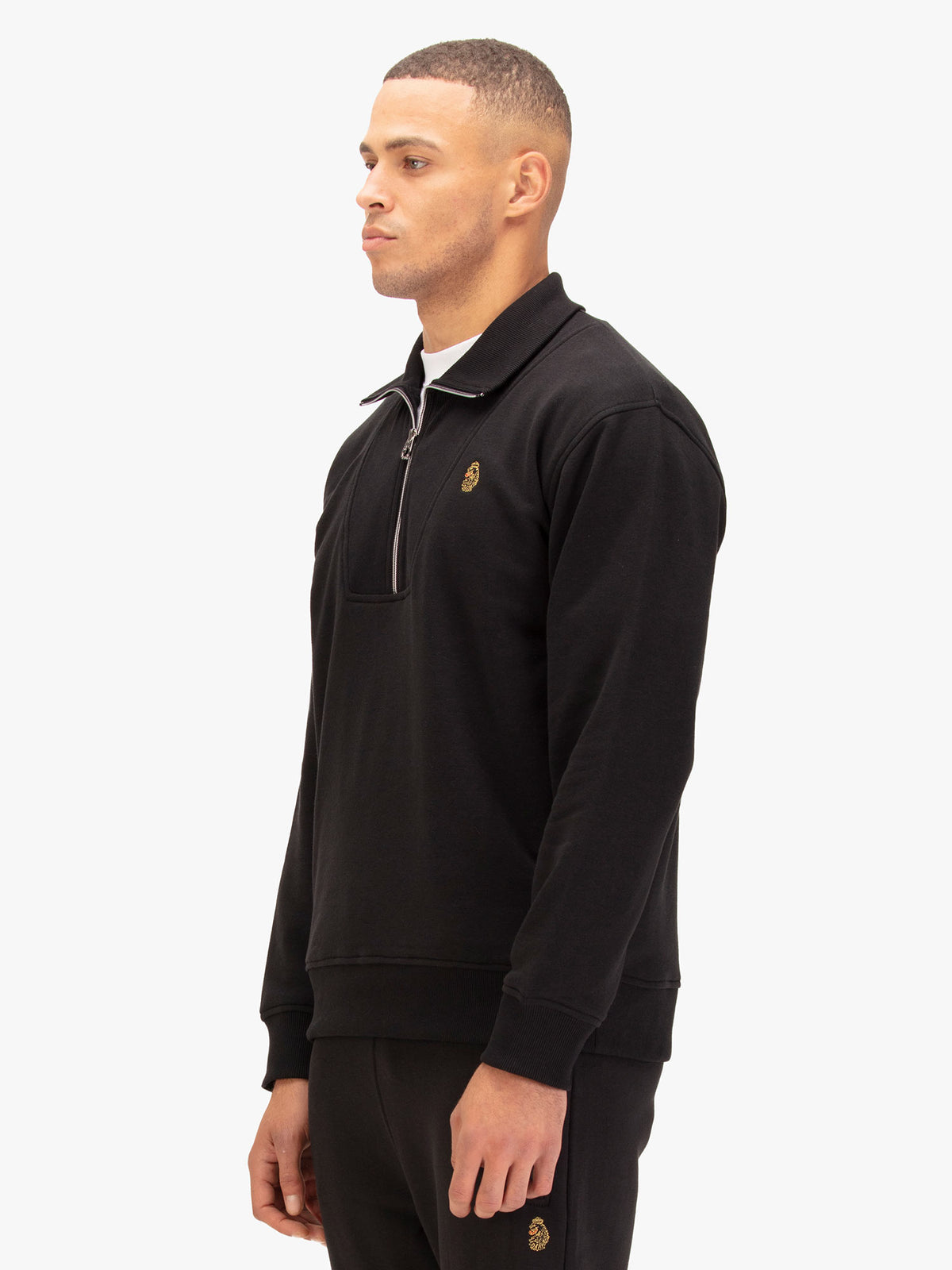 Side view of man wearing black LUKE 1977 Jan Jose quarter zip sweatshirt