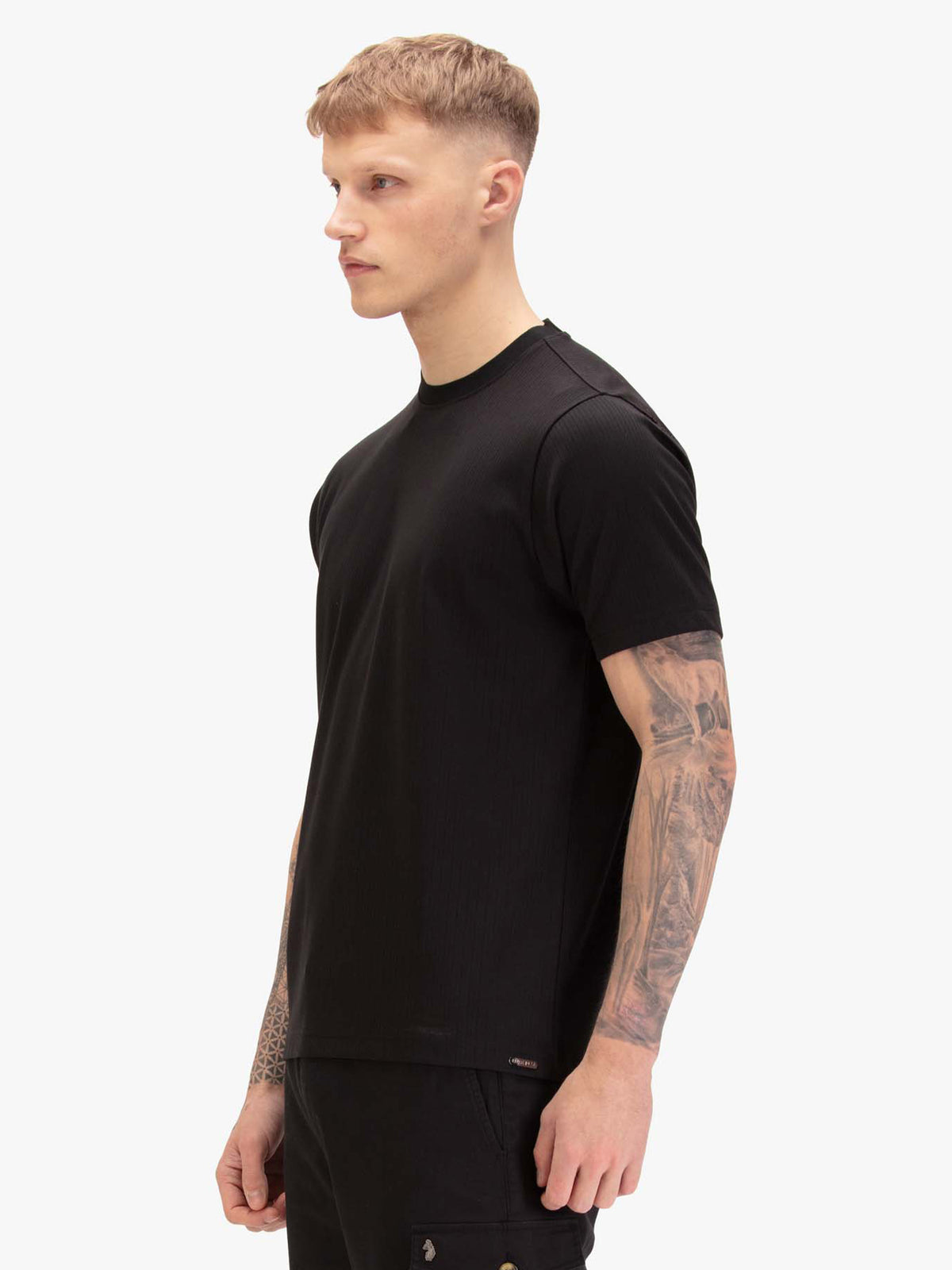 Men's black t-shirt with crew neck and short sleeves, worn by a model, side view