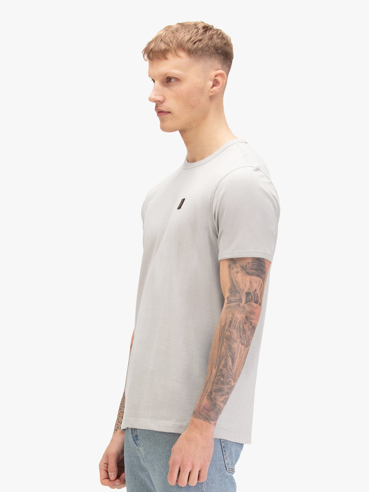 Men's grey t-shirt with crew neck and short sleeves, worn by a model, side view