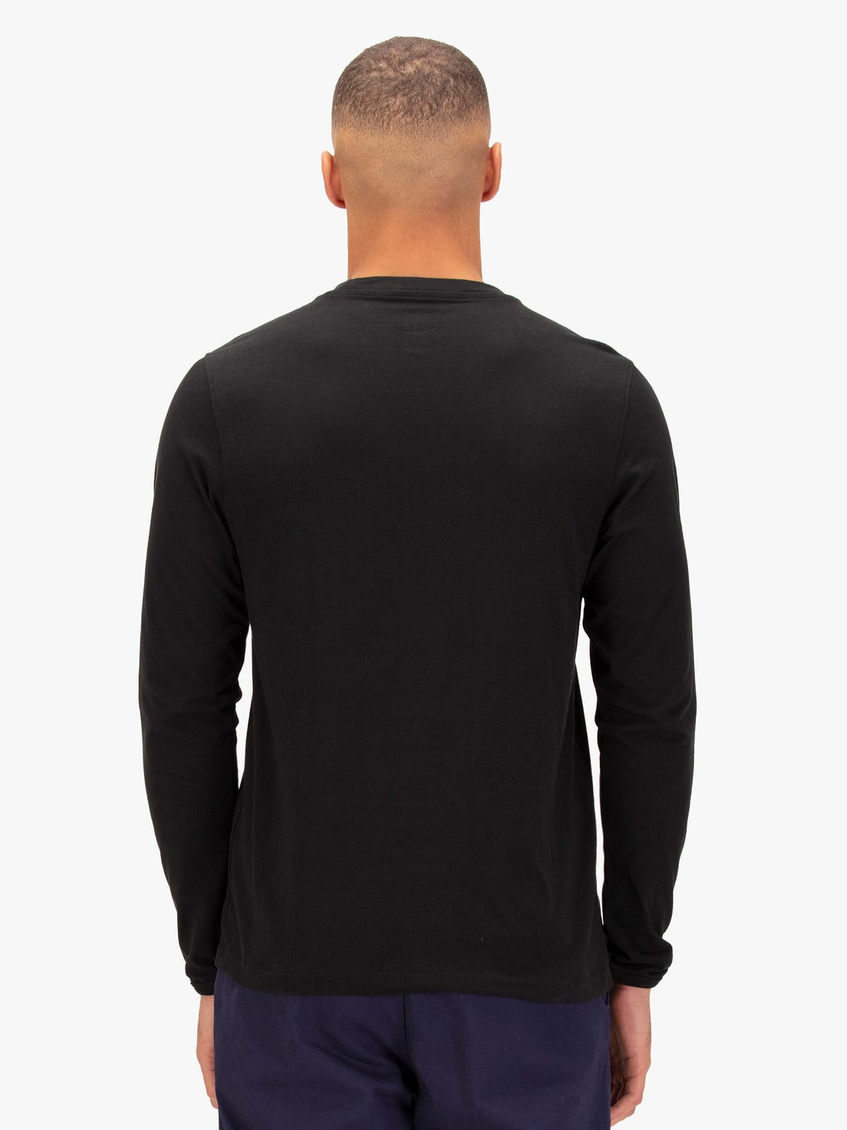 Men's black long sleeved t-shirt with crew neck worn by a model - back view.
