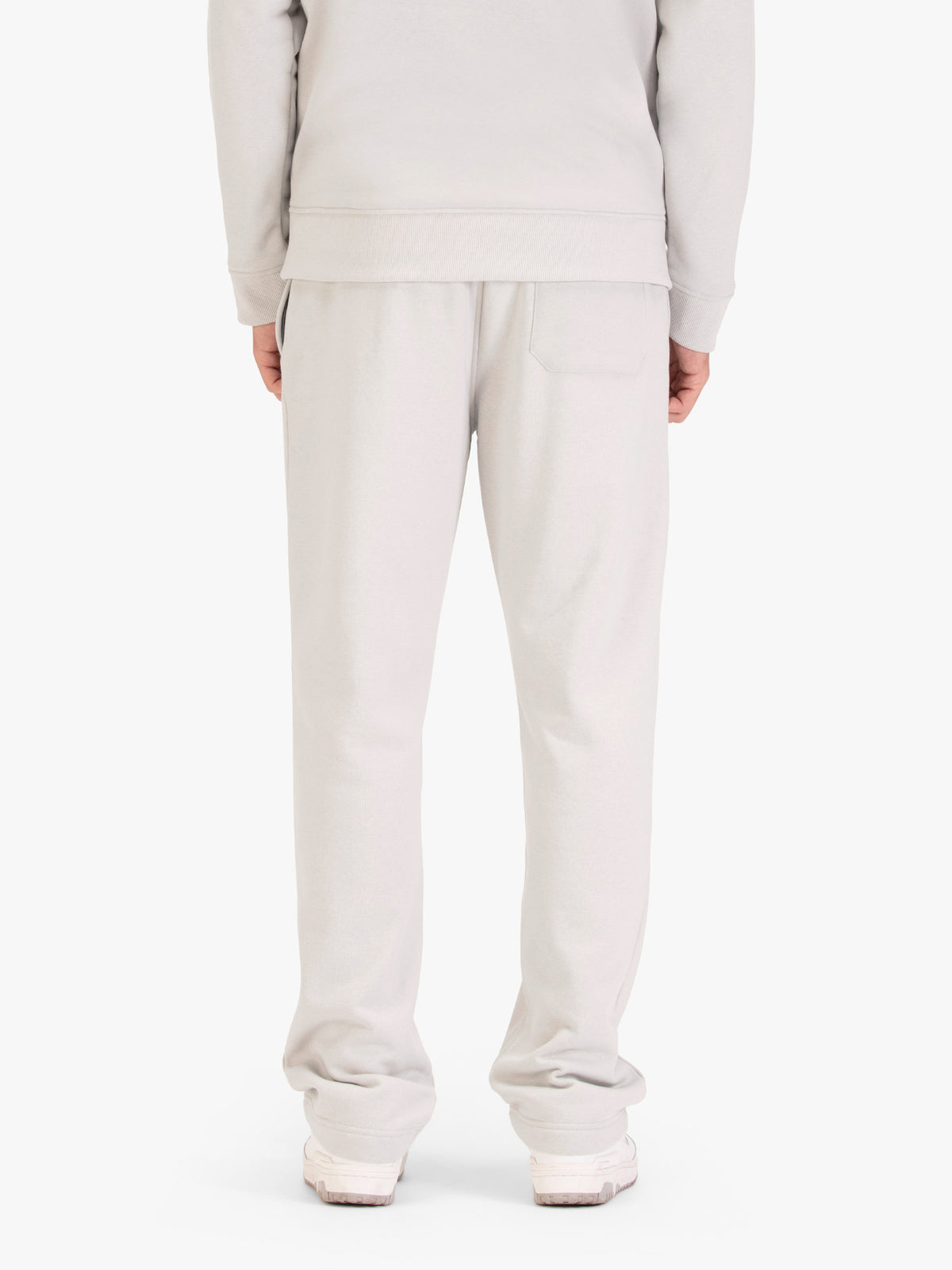 Men's wide-leg grey joggers with drawstring waistband, worn by a model, back view