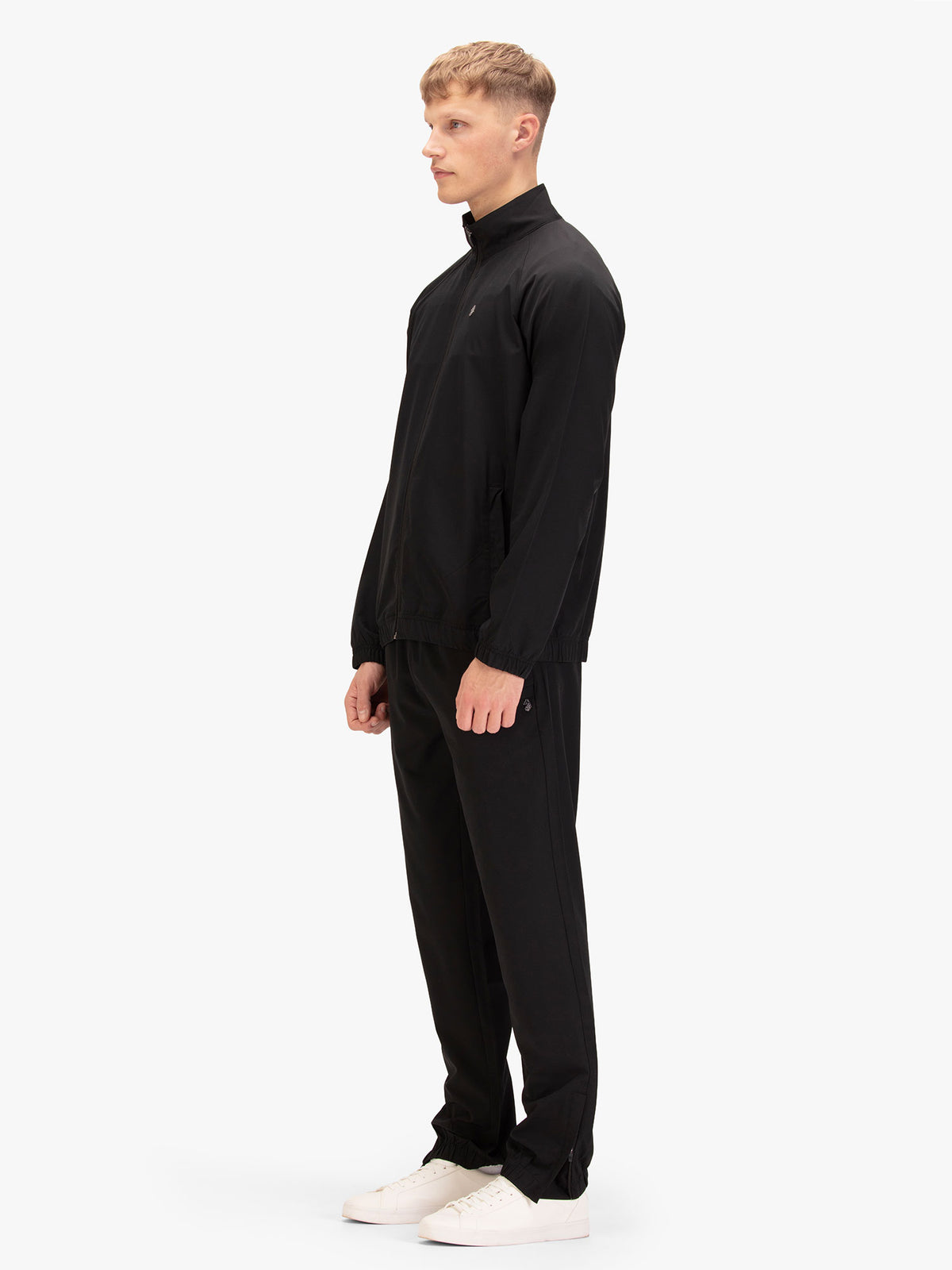 Side view of man wearing black LUKE 1977 Moseley four-way stretch tracksuit