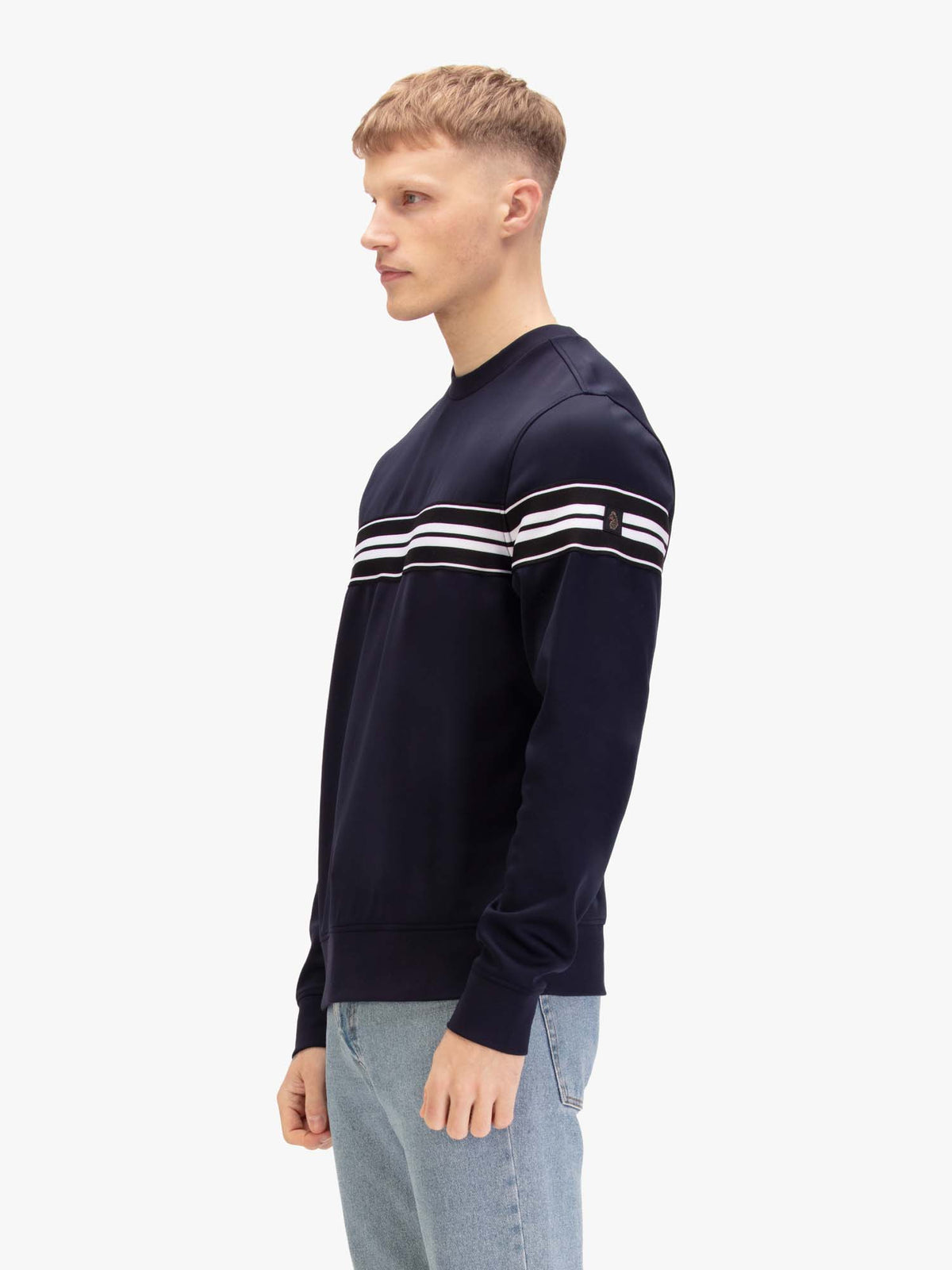 Men's navy sweatshirt with crew neck, worn by a model, side view