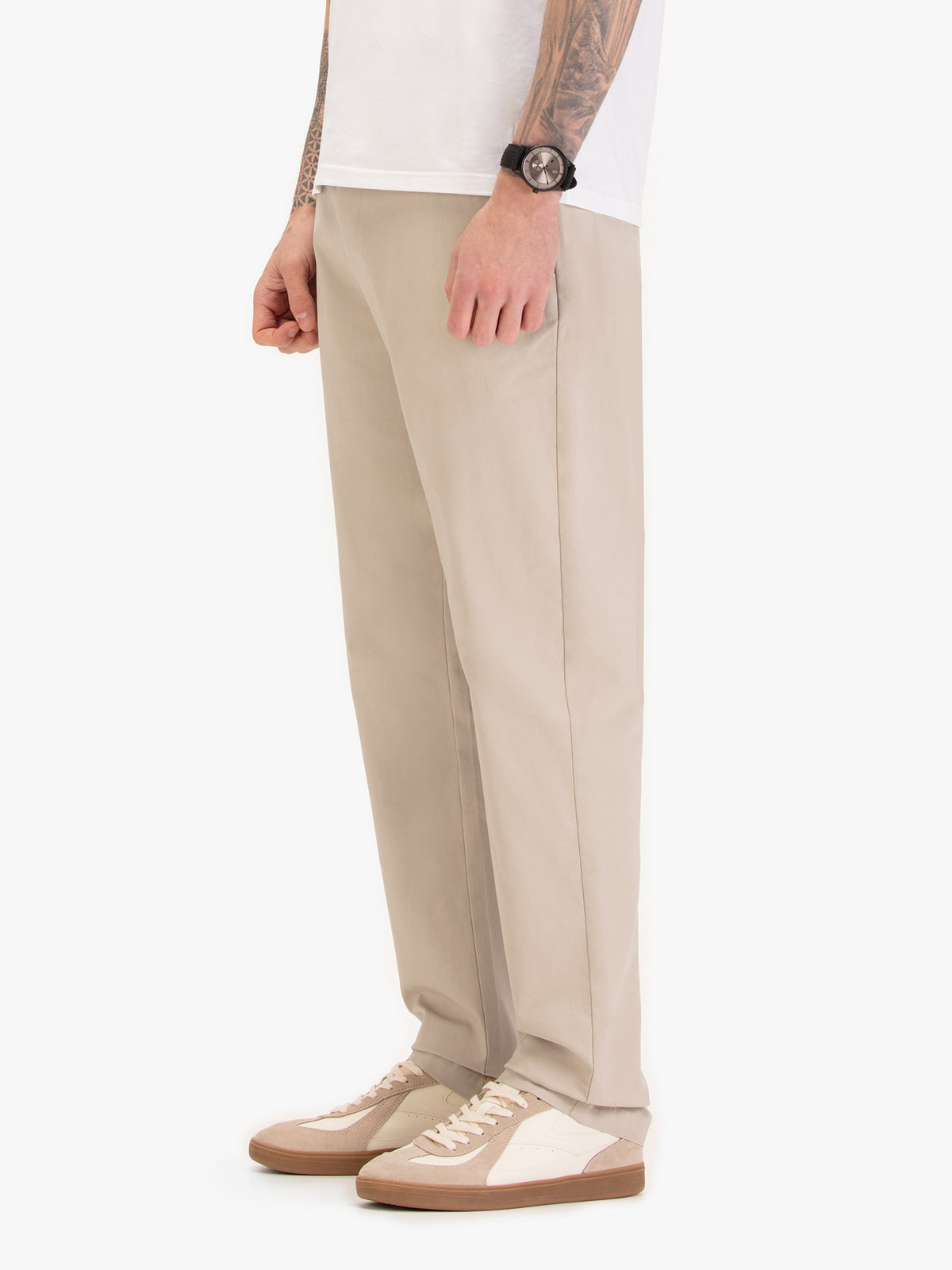 Men's straight-leg beige trousers, worn by a model, side view