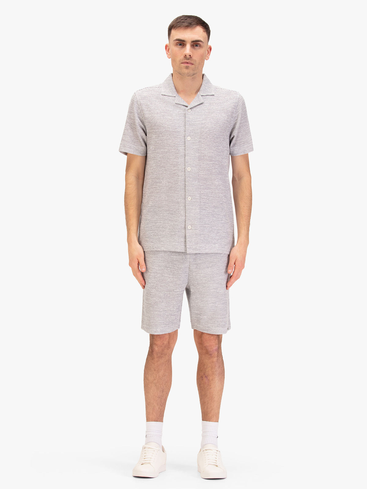 Men's grey short set with short-sleeve shirt and matching shorts, worn by a model, front view.