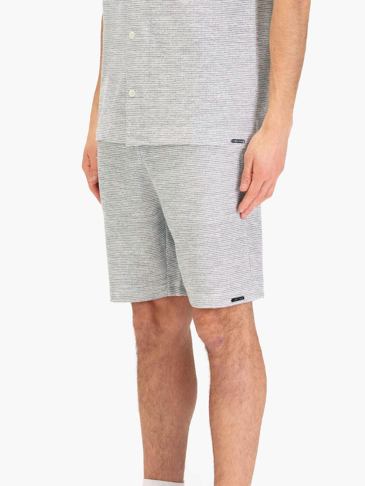 Men's grey shorts with drawstring waistband, worn by a model, side view