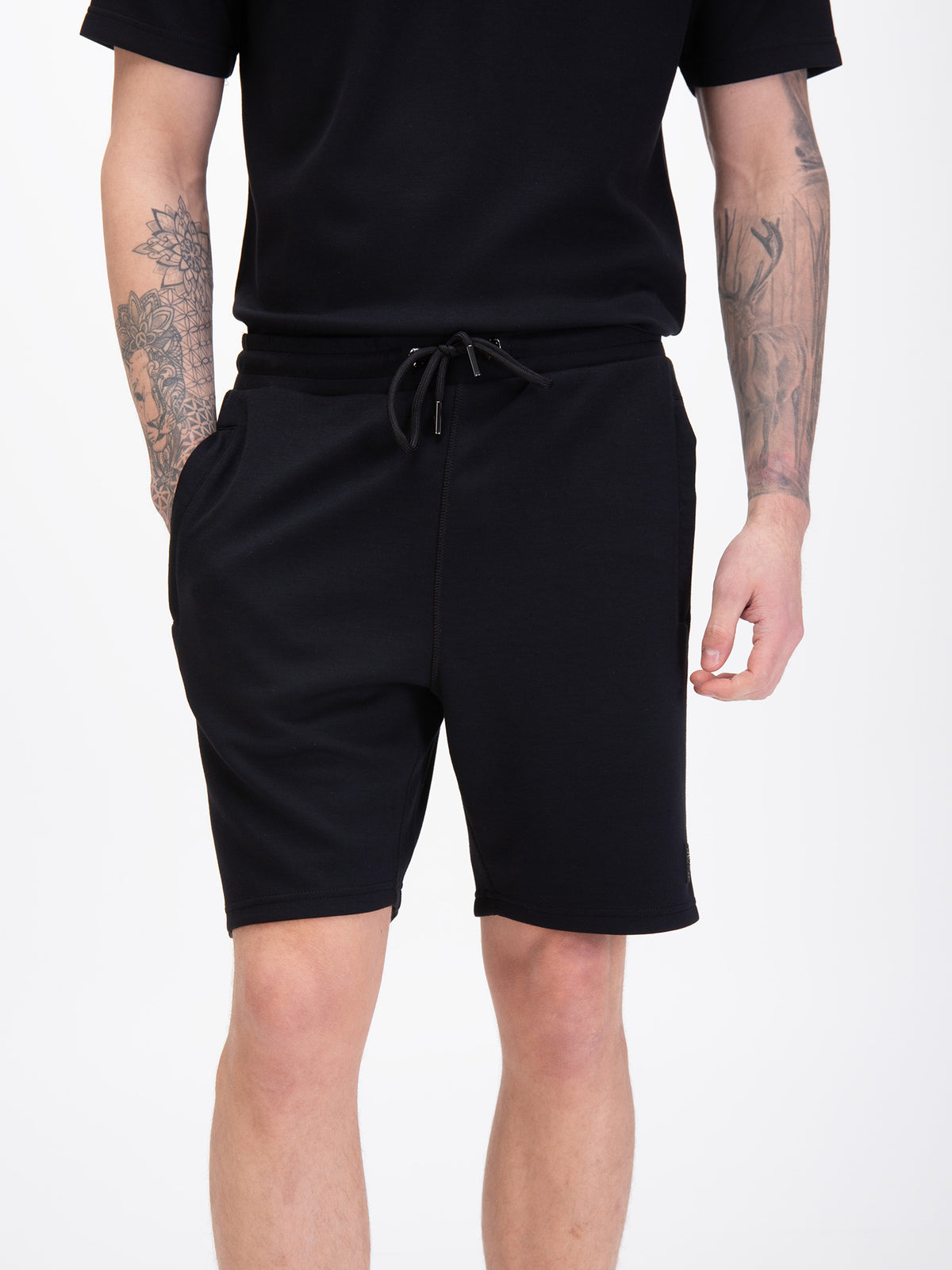 Men's black shorts with drawstring waistband, worn by a model, detail view