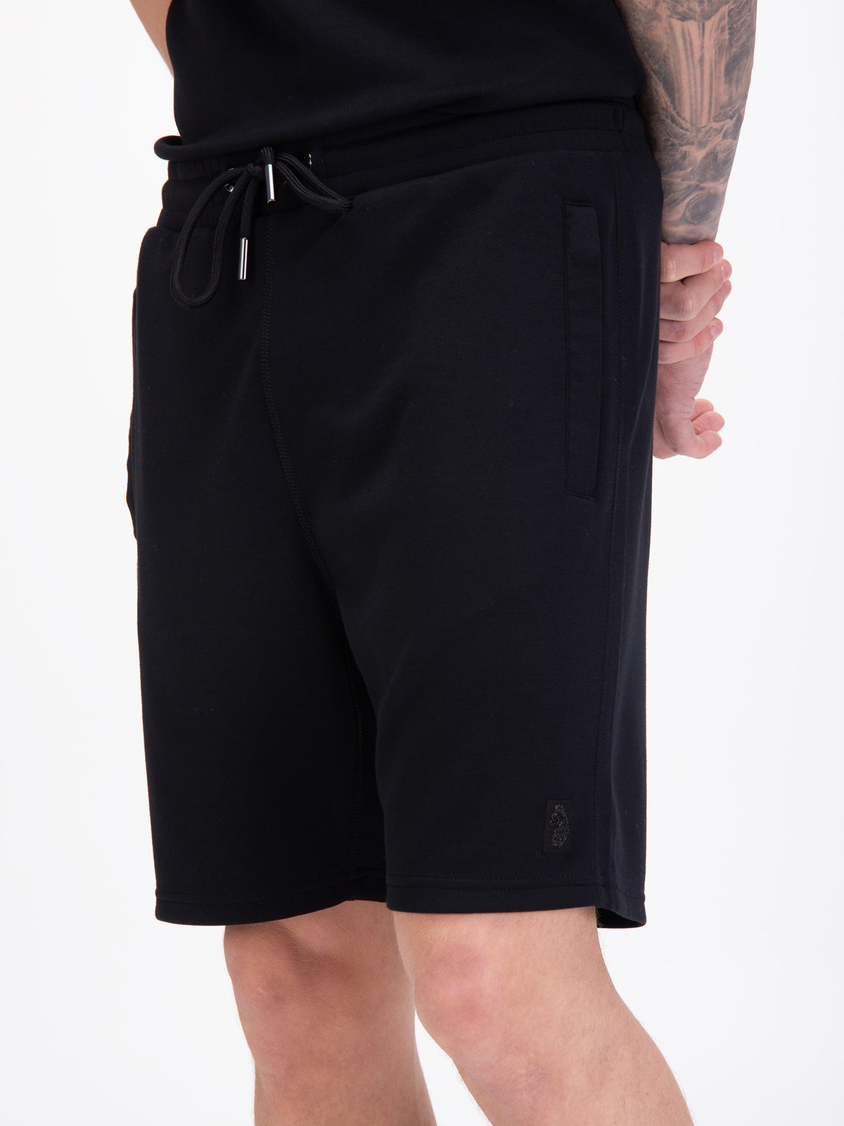 Men's black shorts with drawstring waistband, worn by a model, detail view