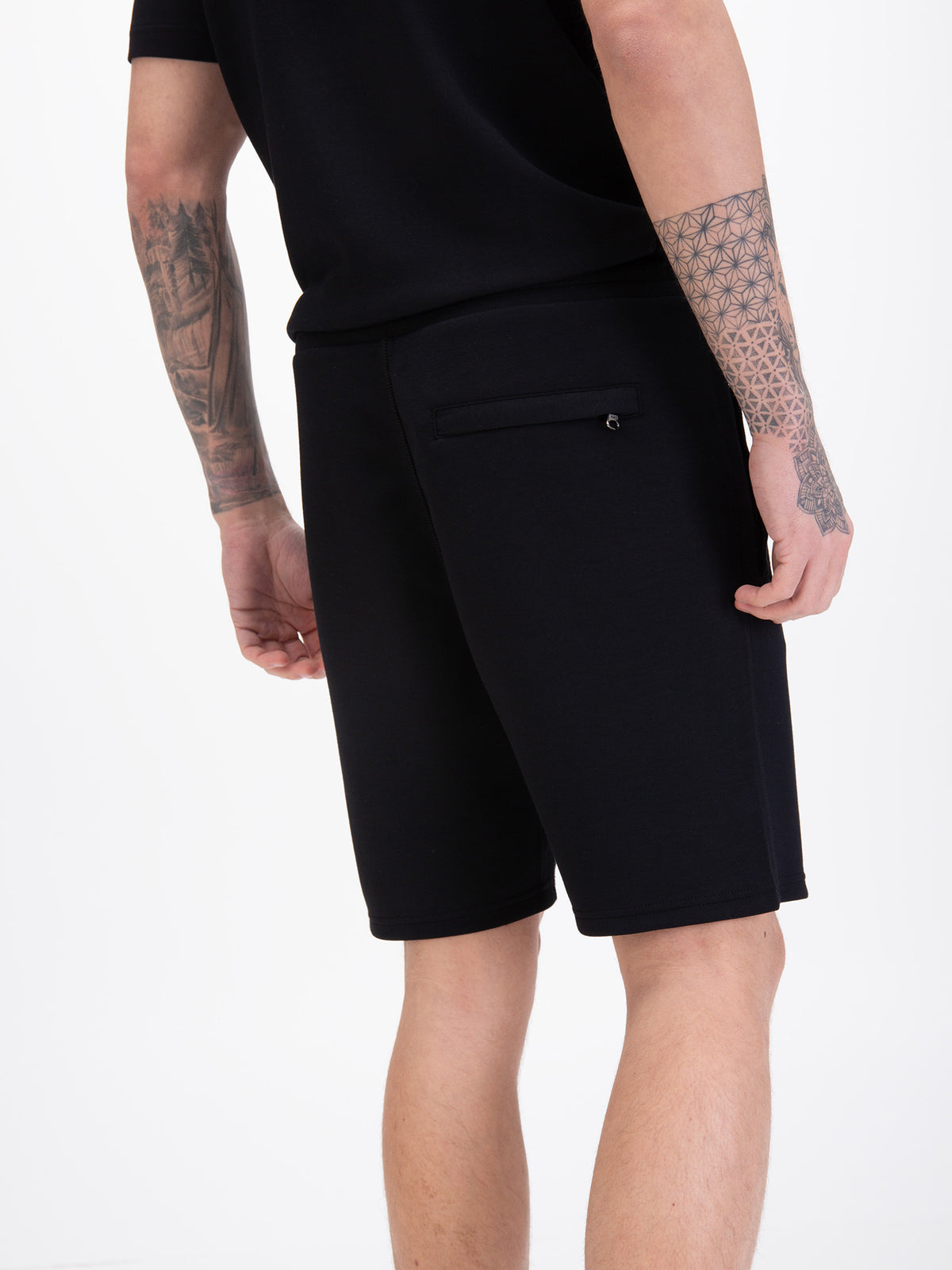 Men's black shorts with drawstring waistband, worn by a model, detail view