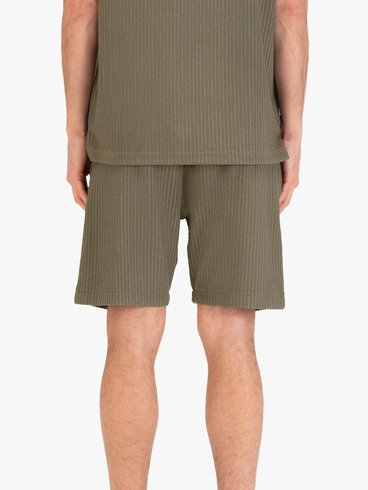 Men's green shorts with drawstring waistband, worn by a model, back view