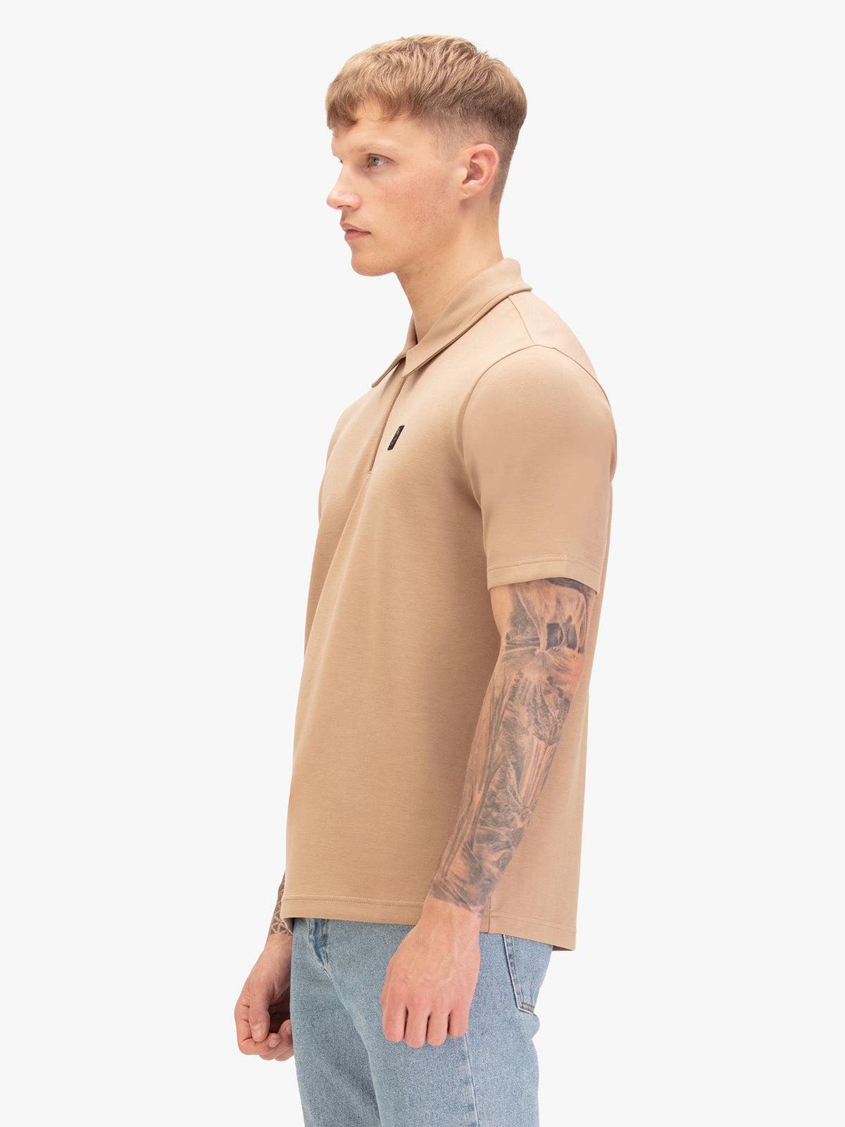 Men's beige polo shirt with polo collar, worn by a model, side view